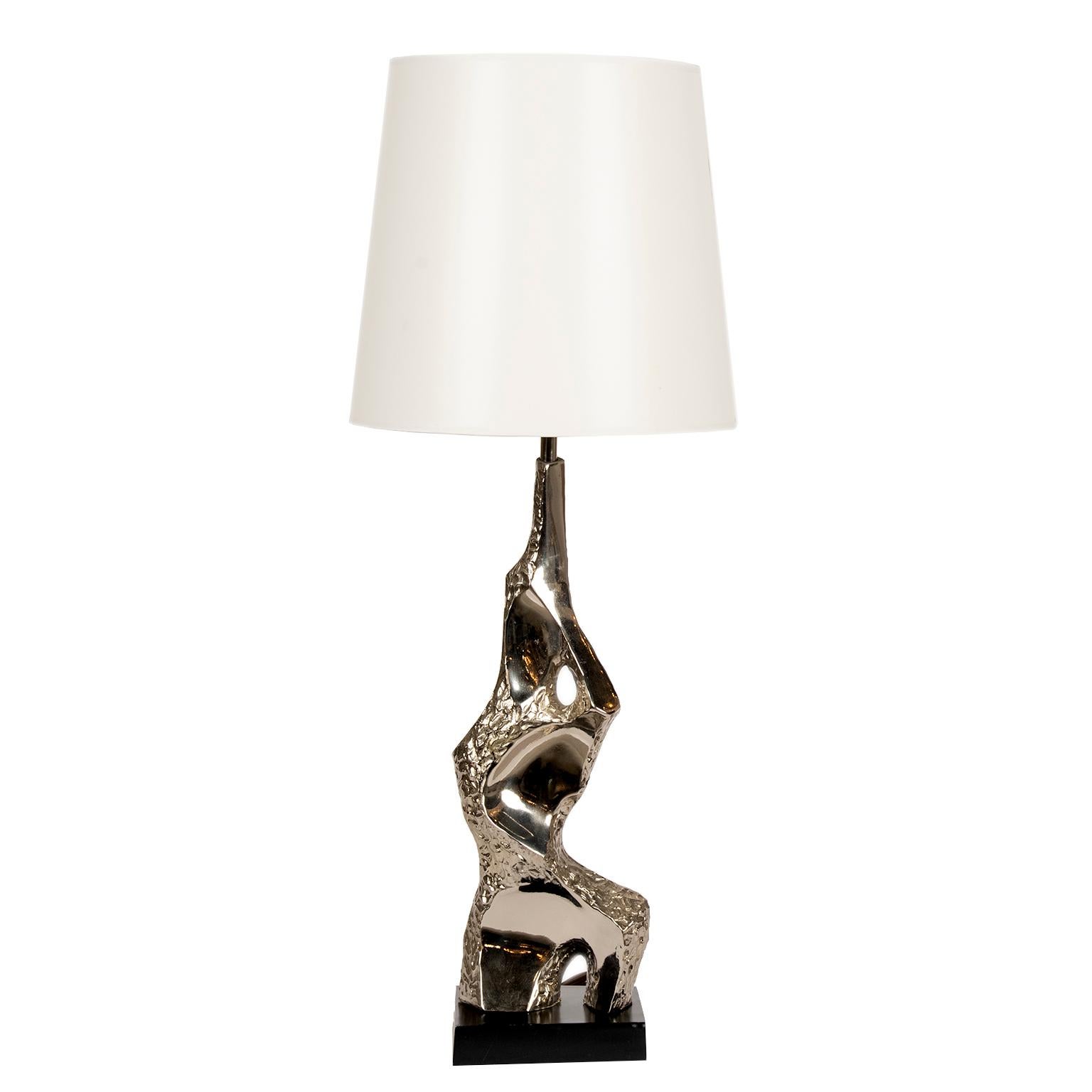 This beautiful tall lamp is as much functional as it is a piece of sculpture.
It features a matte black metal base with a hammered and molded bright chrome body.
This lamp appeared in the Laurel Lamp Company (USA) catalogue in 1965 and is designed