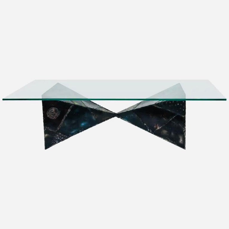 Outstanding brutalist cocktail table with sculptural welded steel base and thick rectangular glass top. The base is comprised of two welded horizontal pyramids with abstract designs and patterns with acid and pigment details in random hues of red,