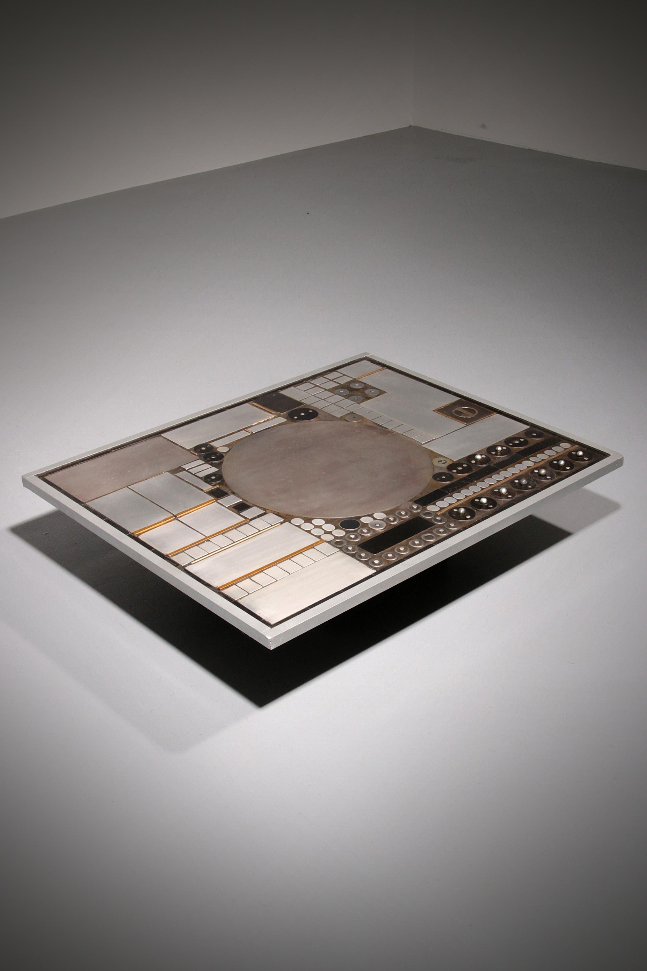 

This exceptional coffee table by Belgian artist Raf Verjans is far more than a piece of furniture; it is a sculptural statement that transforms any interior into a gallery-like environment. The top is composed of multiple aluminum and brass