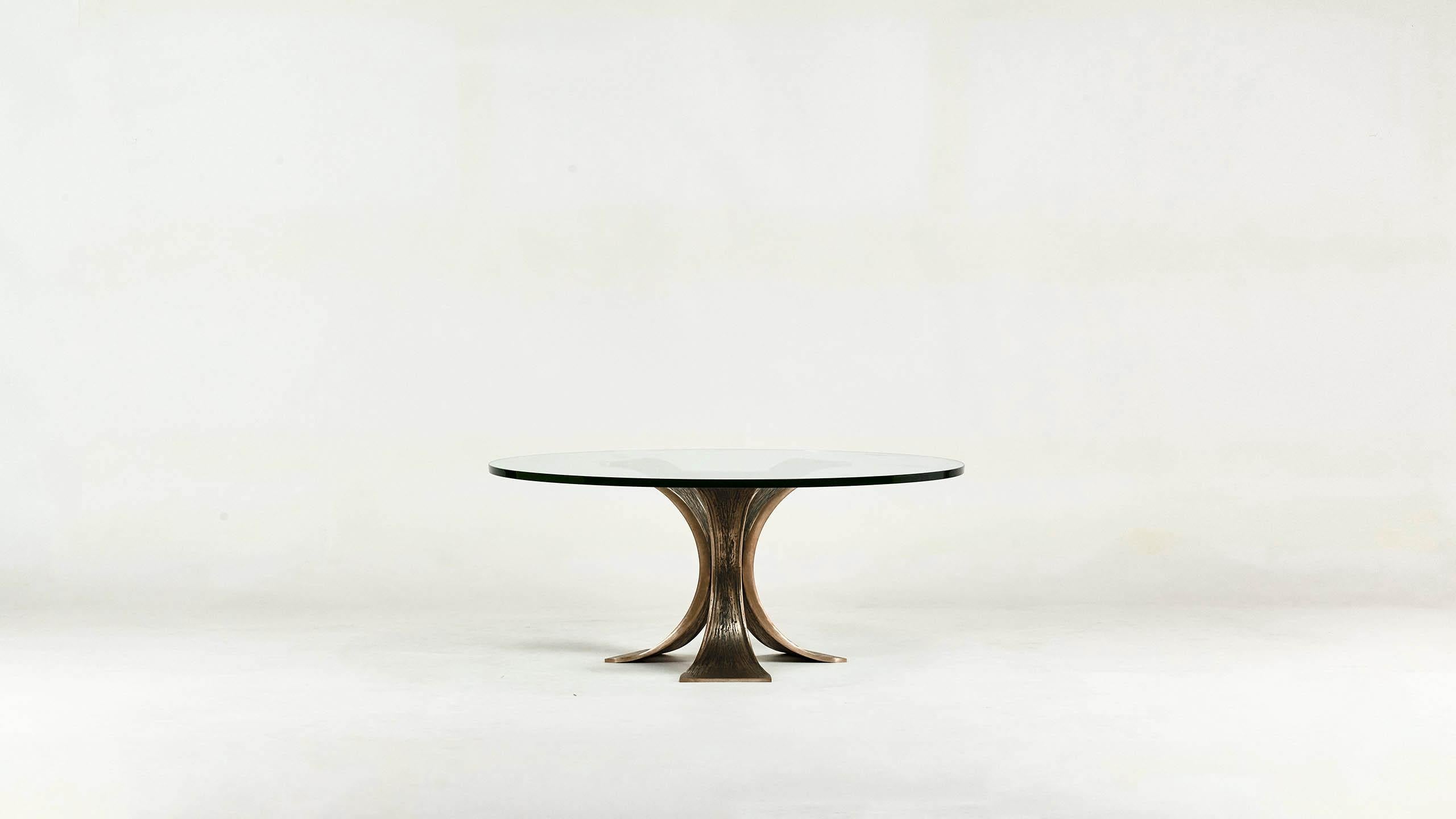 Brutalist tripod coffee table, round in shape, with a 20mm thick round slab of glass supported by a casted bronze base. Excellent condition, beautiful patina, Germany, circa 1970.