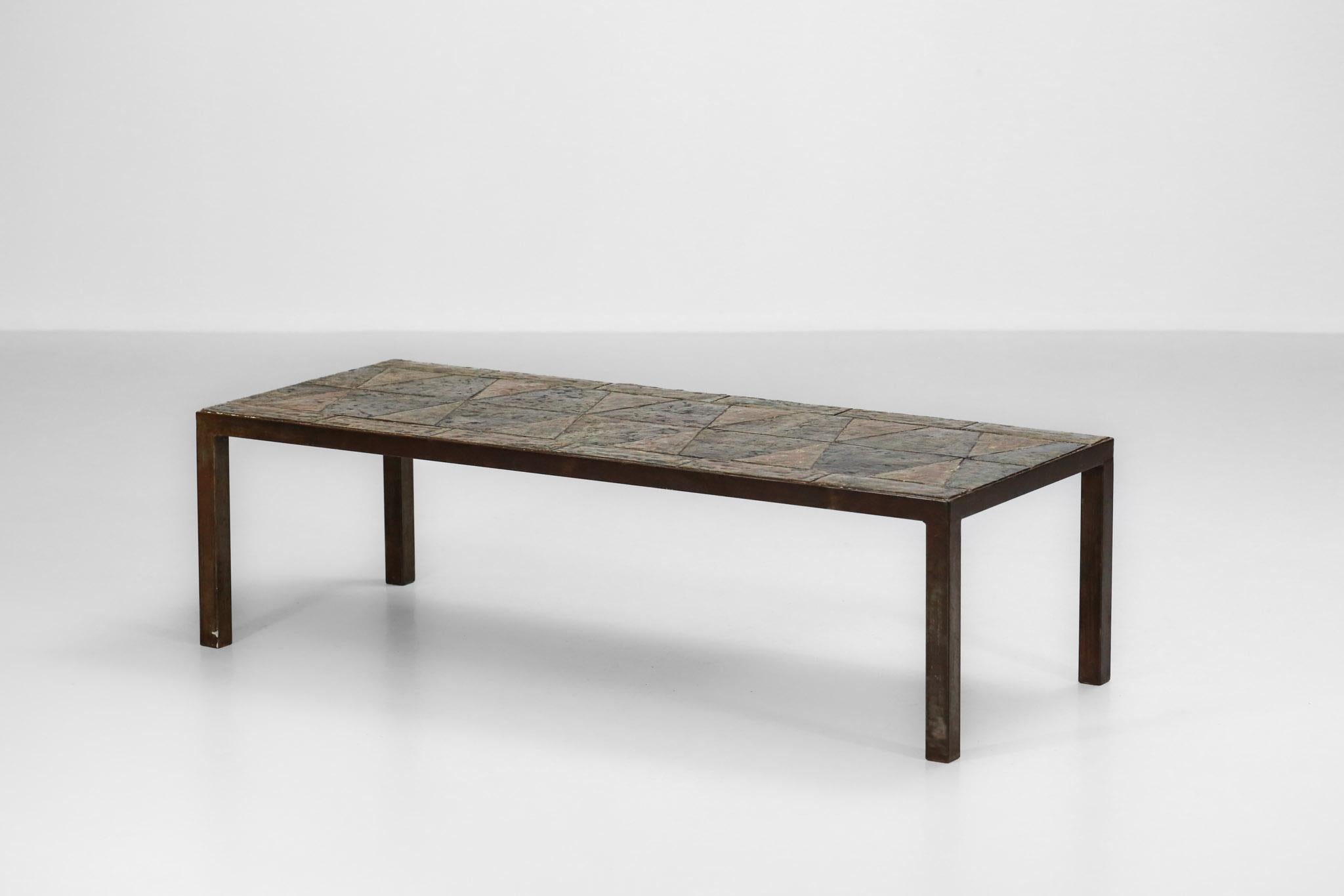 Brutalist coffee table from the 1960s made of enameled lava stones forming a geometrical decoration.
Legs in raw steel.