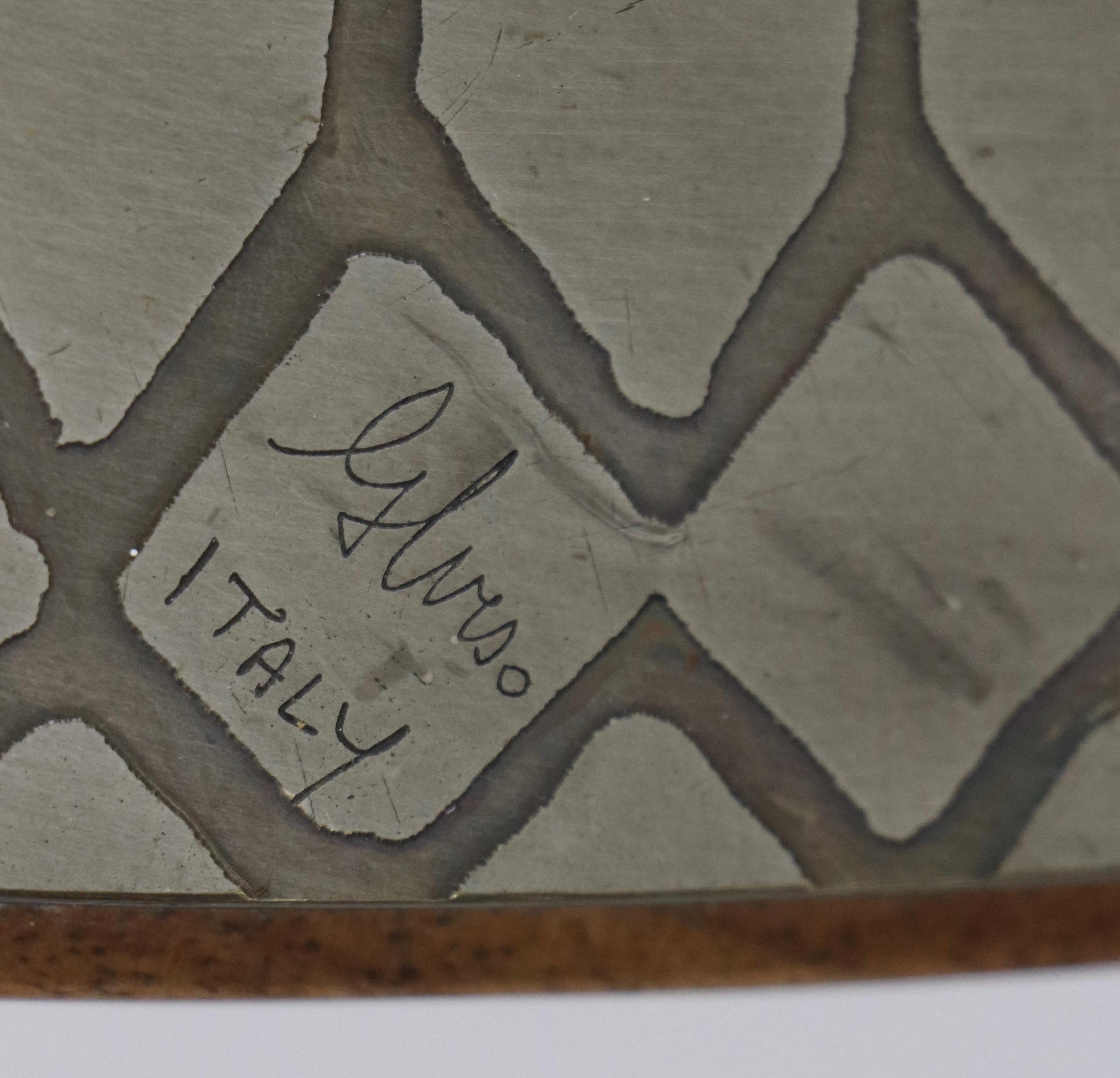 Interesting round coffee table with dimensional metal top in the Aztec style, signed  by the artist  - G. Urso and signed Italy. The metal disk top is situated on a wood base of hexagonal form.