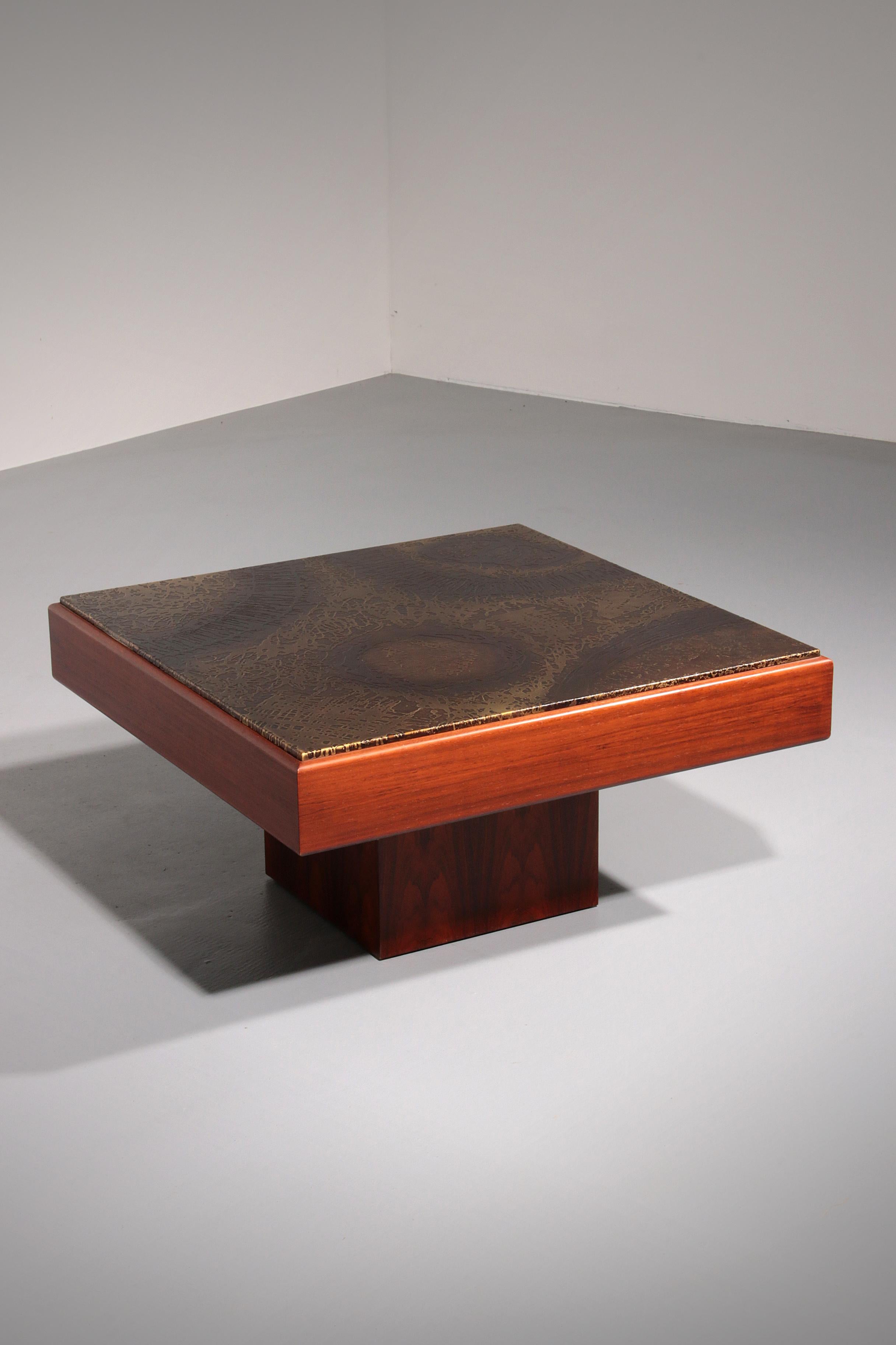 Dieser auffällige brutalistische Couchtisch, der in den 1970er Jahren in Belgien hergestellt wurde, hat eine wunderschöne handgearbeitete Kupferplatte, die auf einem skulpturalen Massivholzsockel ruht. Sein kühnes und doch minimalistisches Design