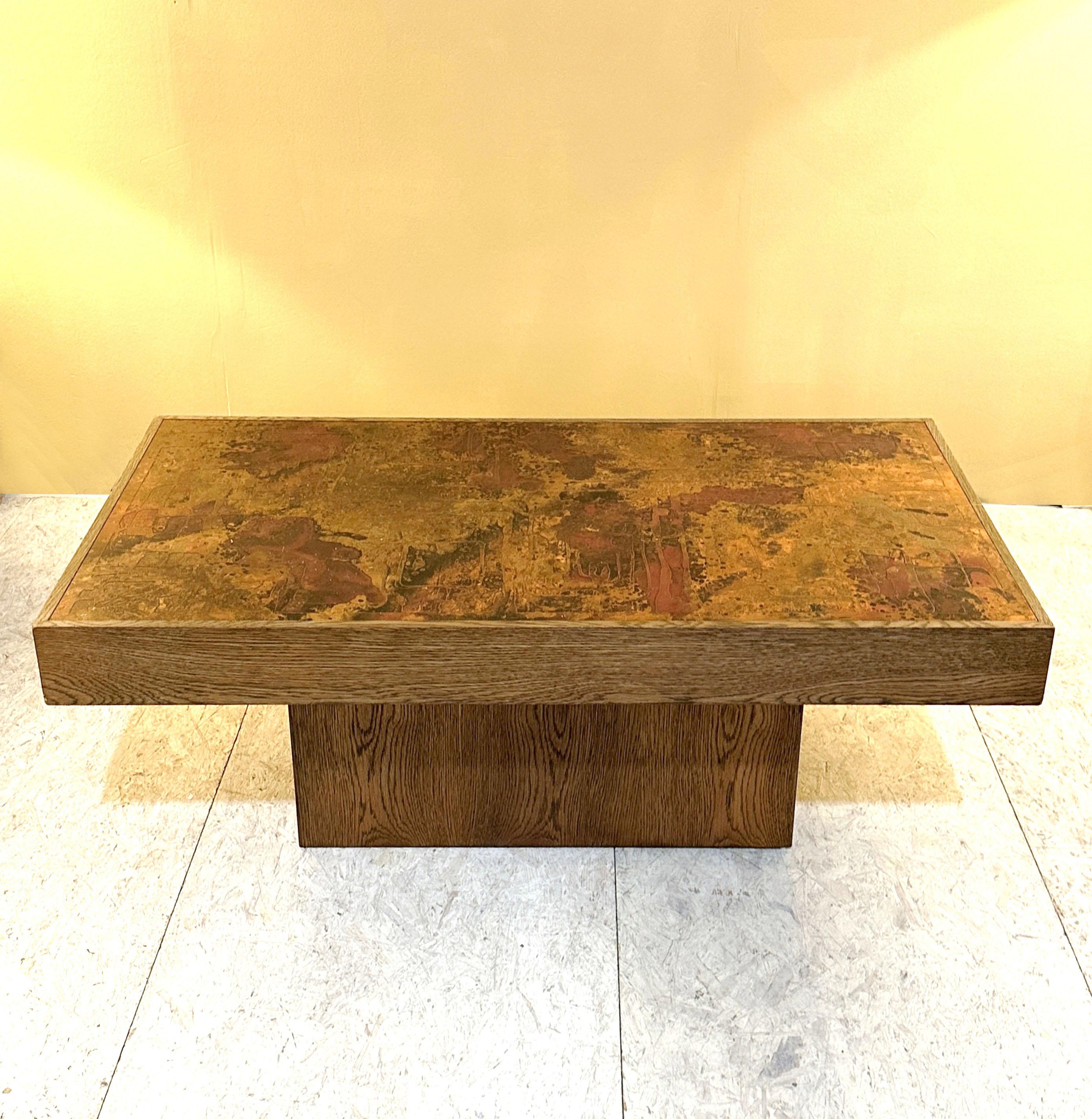 Coffee designed in the 1960s by Bernhard Rohne, this table features an incredibly intricate surface made with innovative etching and patination techniques on a copper plate with his signature incorporated. The table is edged with an oak border and