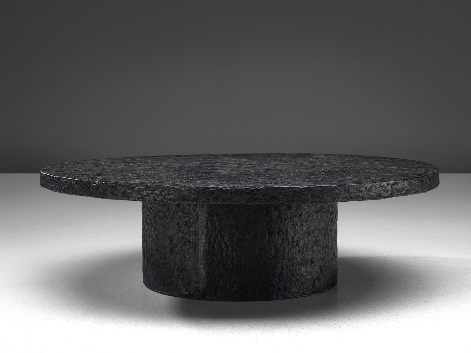 Cocktail table, resin, stone Northern-Europe, 1970s. 

This deep black to brown robust coffee or cocktail table is from the 1970s. The thick round top is supported by a similar but smaller round column. This low table is made out of resin which