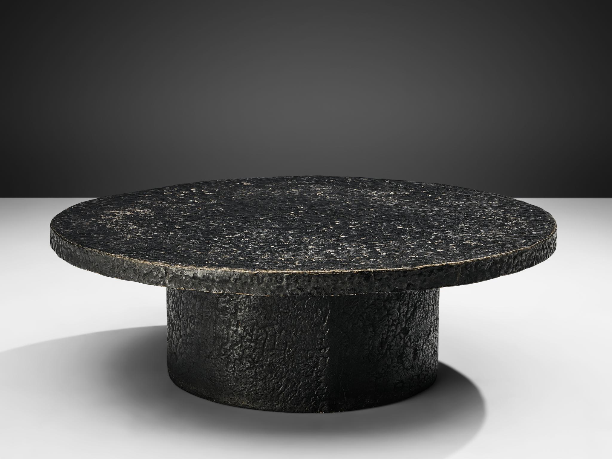 Cocktail table, resin, Northern-Europe, 1970s.

This deep black to brown robust coffee or cocktail table is from the 1970s. The thick round top is supported by a similar but smaller round column. This low table is made out of resin which resembles