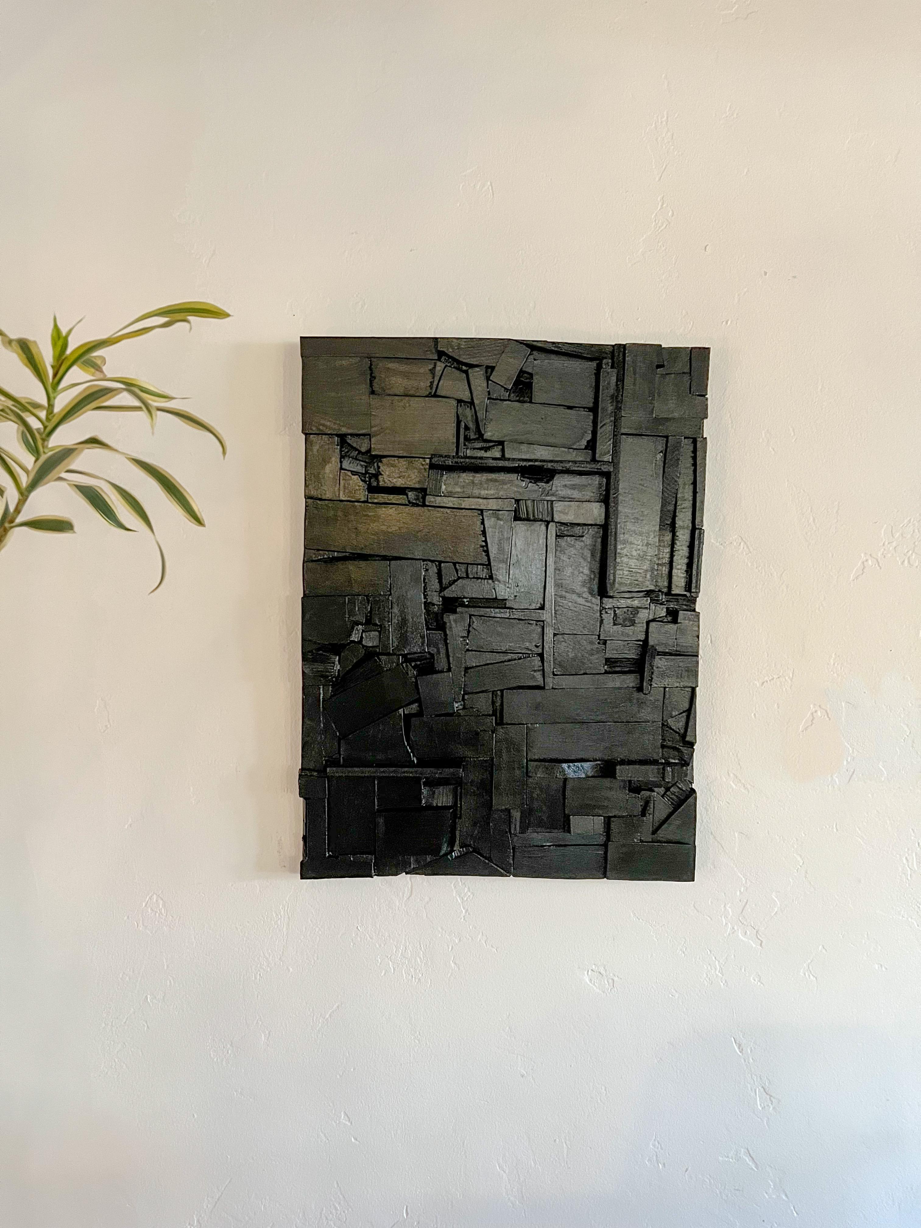 This striking wooden wall sculpture is a one-of-a-kind studio piece that embodies the bold architectural language of brutalist design, in the style of Louise Nevelson and mid-century assemblage artists.

Meticulously handcrafted from reclaimed wood,