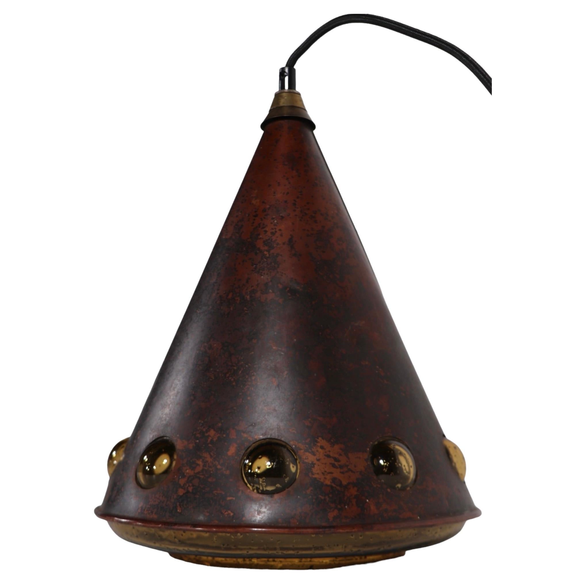 Exception cone form hanging pendant designed. by Nanny Still McKinney, for Raak - circa 1960's. The chandelier features a copper exterior skin with an amber glass interior, with decorative bubble like dot form windows. 
 Excellent, clean, working