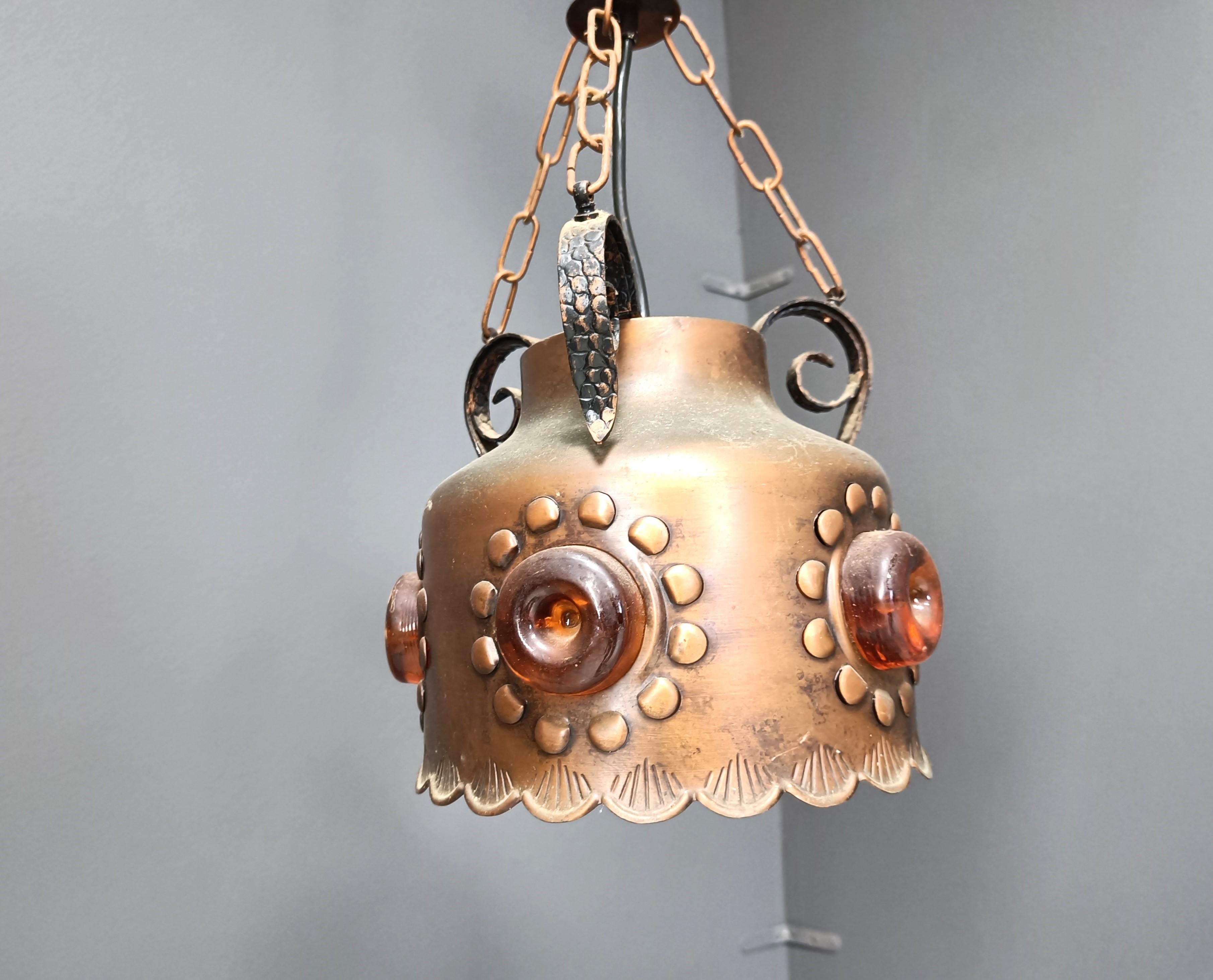 Lampada a sospensione brutalista vintage in lamiera di rame martellata.

La lampada emette una luce calda e diffusa grazie al vetro arancione integrato.

Anni '70 - Paesi Bassi

Testato e pronto all'uso con una lampadina E27. Lavora in tutto il
