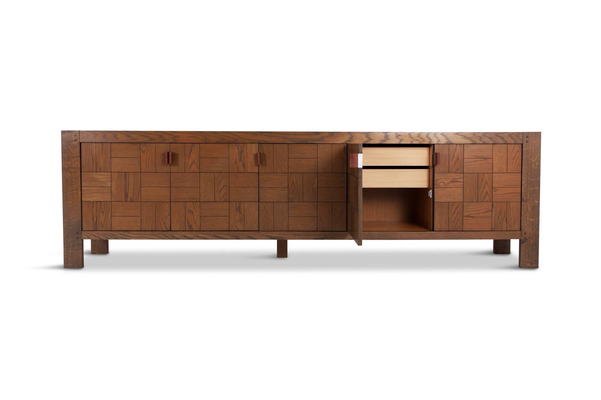 Postmodern Scarpa style Brutalist credenza. The cabinet is provided with geometric door panels with stained oak inlay and finished with beautiful cognac leather door handles. The cabinets show a beautiful grain and provide plenty of storage