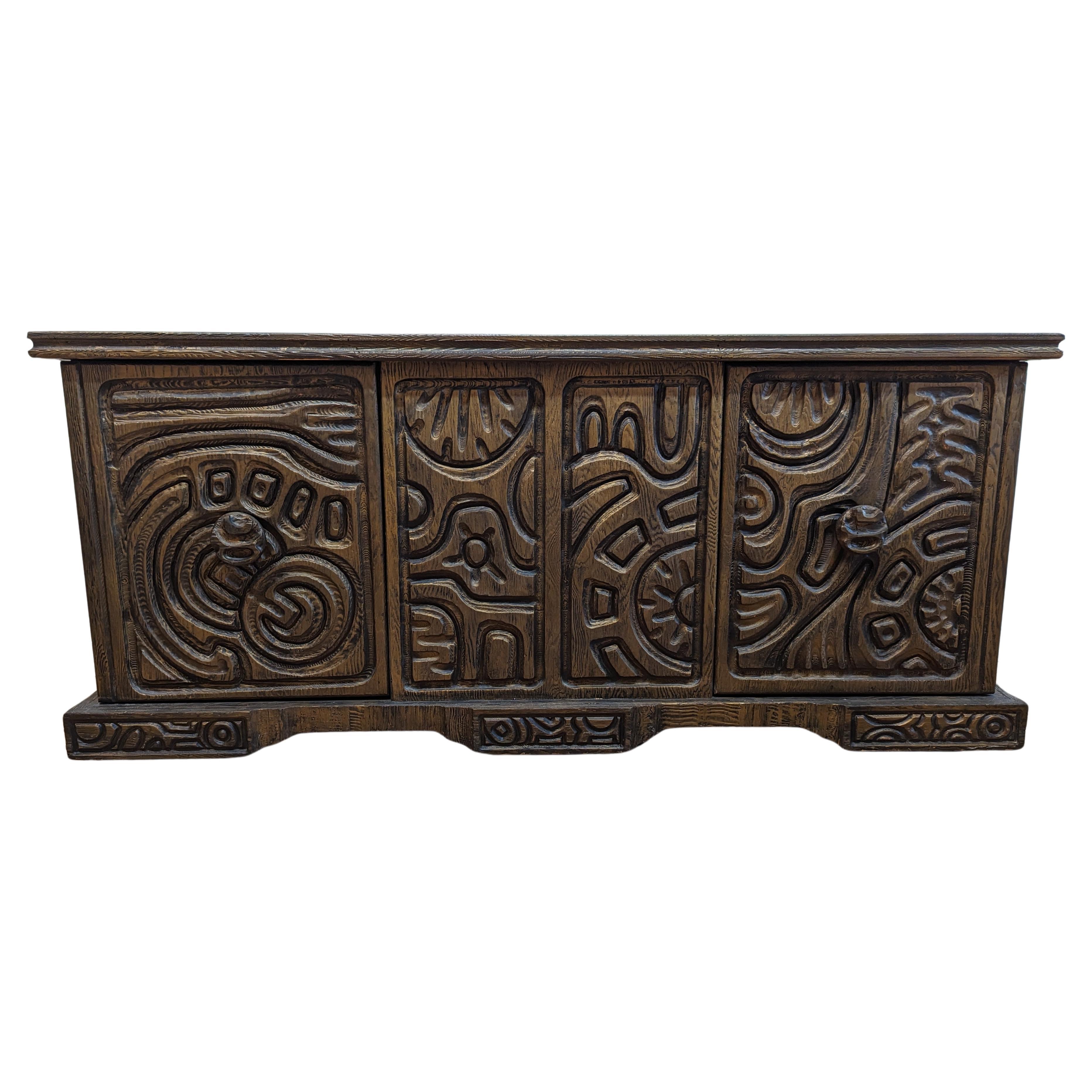 A fantastic Brutalist Credenza Sideboard by William Westenhaver for Witco.  Carved wooden panels with great depth and detail decorate the entire body of this sideboard.   The front has two cabinets doors that open to drawers on the top and cabinet