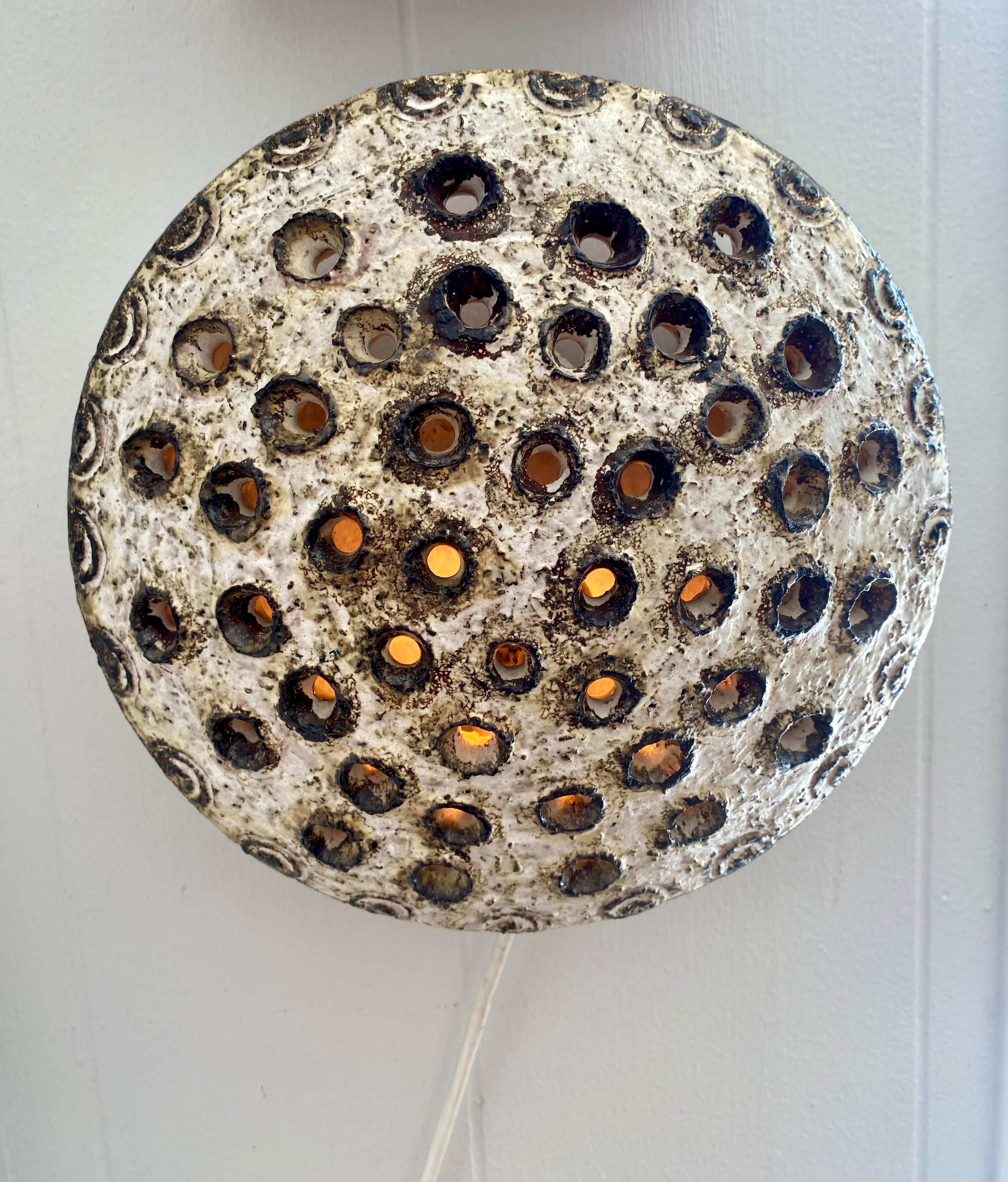 Danish modern brutalist handmade ceramic wall sconce with perforated holes to diffuse light. This is a plugin wall sconce; European plug can be fit with a U.S. adapter. 110-150v

Dimensions: 10