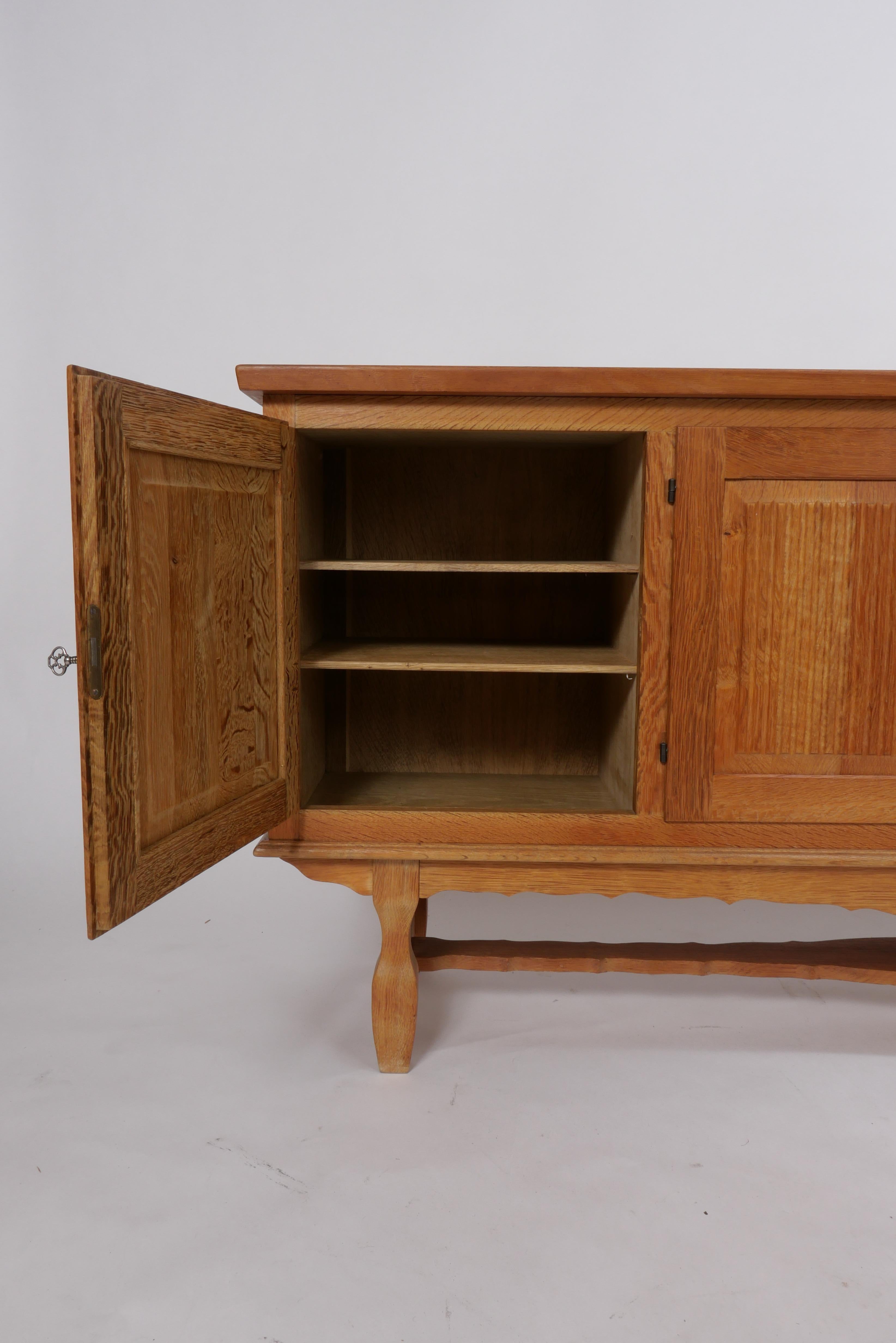 Solid carved oak buffet or sideboard from Denmark circa 1960s-70s. Recently imported and in fantastic condition with age-appropriate character and beautiful construction. Locking doors reveal adjustable shelving and drawers inside lined in felt for