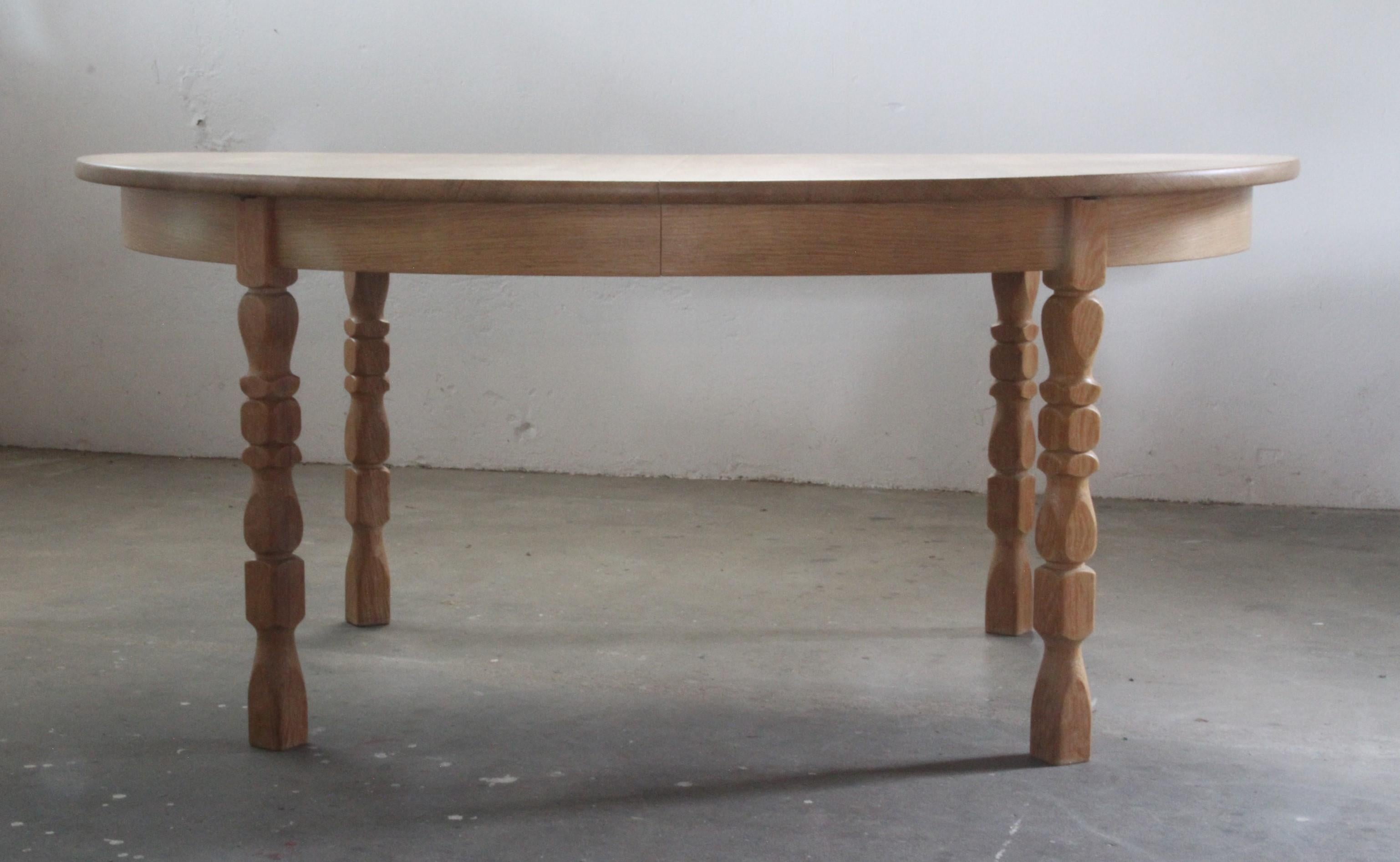 This vintage oak table shares the essence of Kjaernulf's furniture design. Its brutalist aesthetic, highlighted by intricate leg carvings, is beautifully balanced by its rounded (egg) shape. In excellent vintage condition and gliding smoothly, it