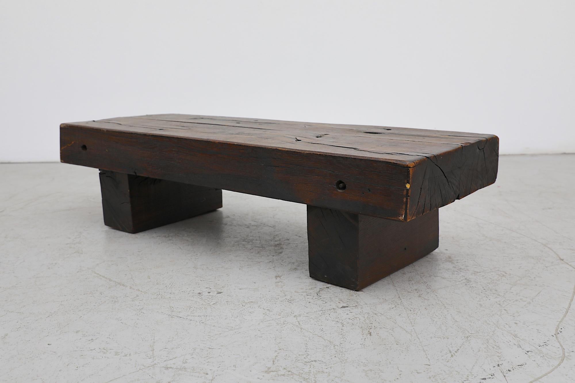 Robust brutalist railroad coffee table or bench made of three very heavy solid dark oak pieces, the top rests on the two legs. In original condition with visible wear, including scratches. Wear is consistent with its age and use.