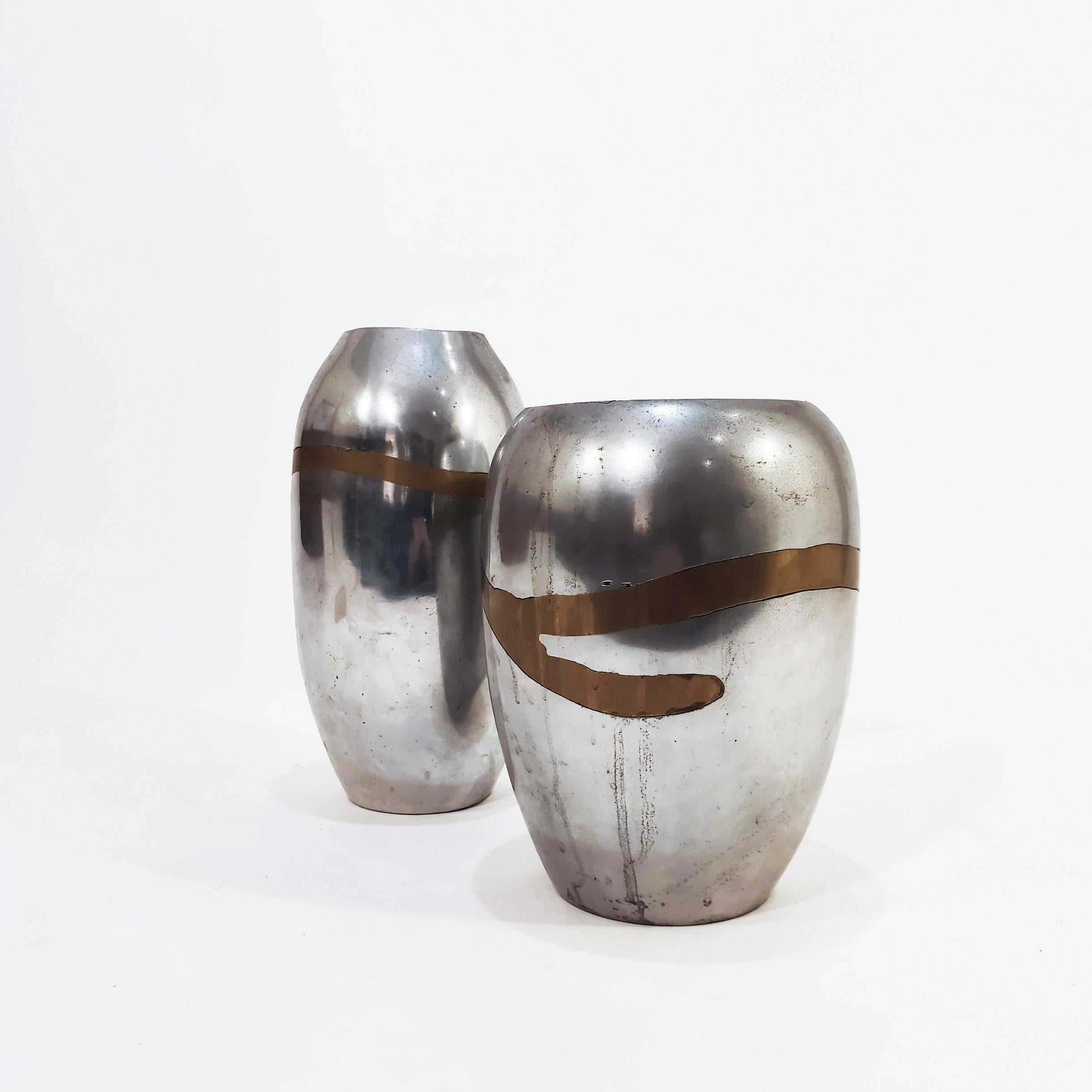 Pair of big vases in the brutalist style by the Spanish designer Alfonso Márquez, 1970s. Both pieces are entirely made of metal, combining polished aluminum and brass. The labels are still intact, and the stamp on the base can also be seen (see last