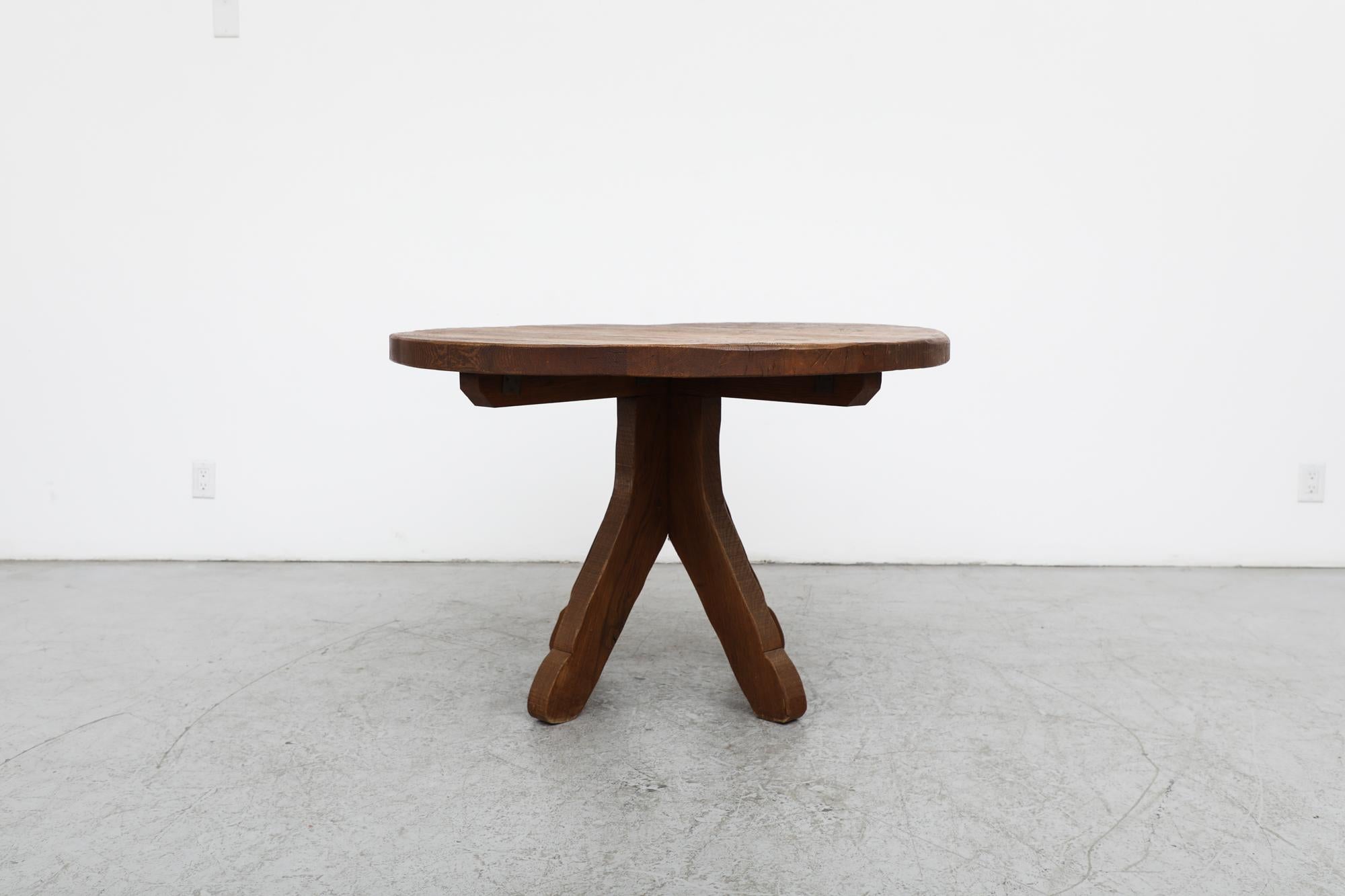 Handsome Mid-century De Puydt attributed natural oak dining table with round top and organically carved, brutalist pedestal base. Sharp but organic silhouette with in heavy, solid oak wood The table is in original condition with some light wear
