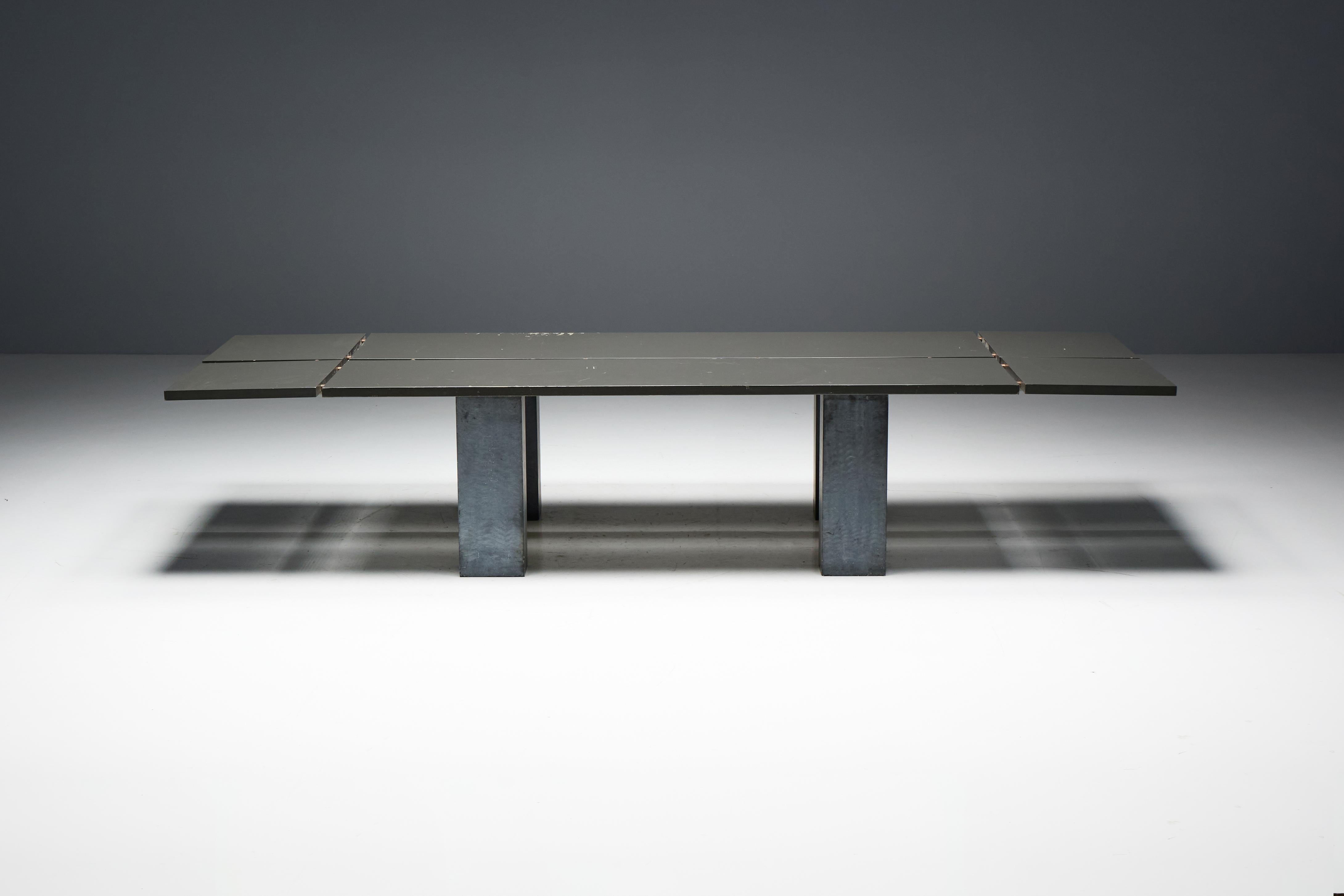Cette table saisissante associe des matériaux industriels bruts à un design épuré et minimaliste. Le plateau est fabriqué en bois durable, tandis que des connecteurs métalliques donnent à la surface un aspect segmenté. Les pieds robustes sont
