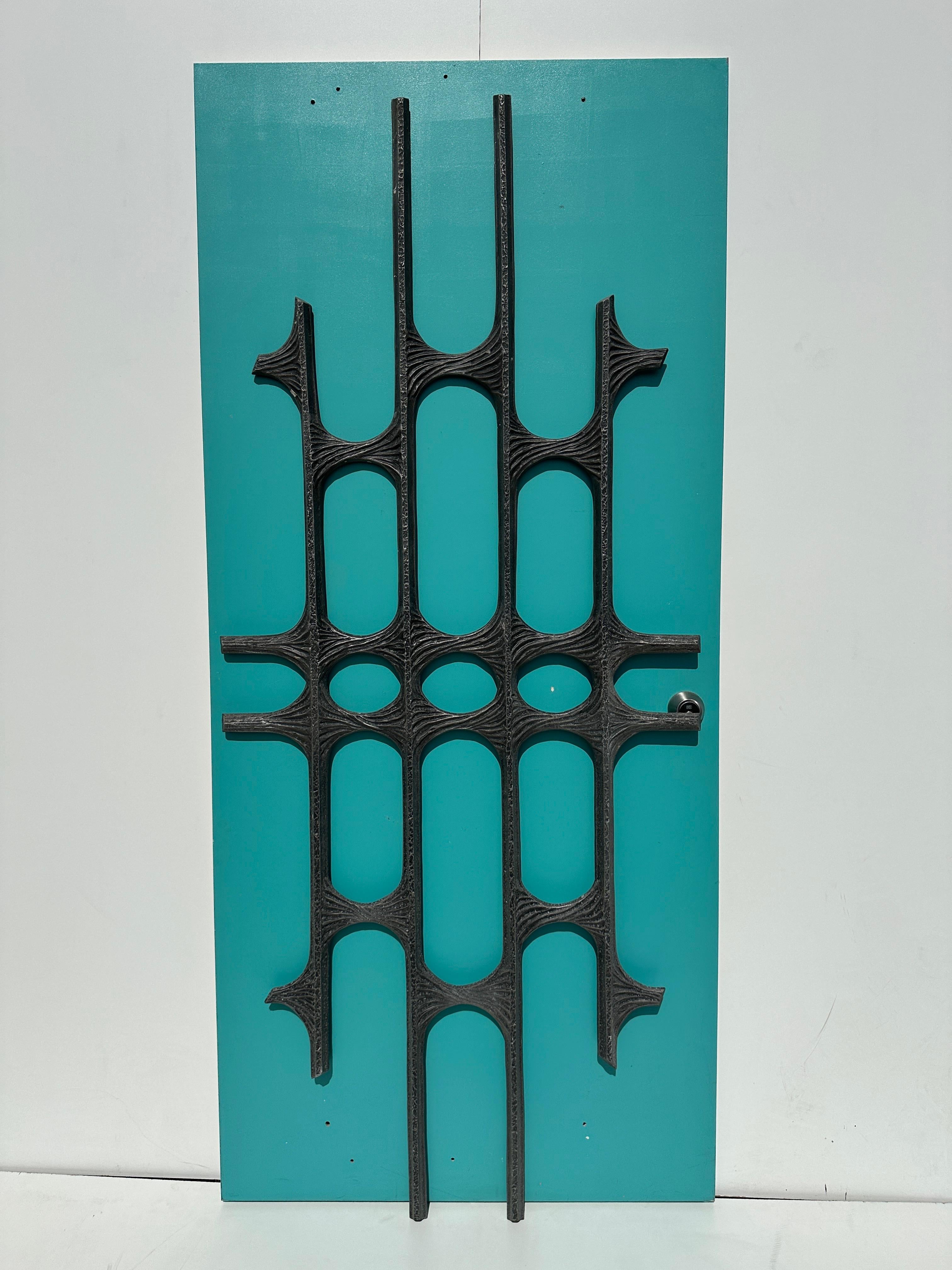 Cast aluminum brutalist wall decoration or door panel. 
Can be attached to your existing door or just hang on the wall.  Similar item was featured on Architectural Digest magazine.
