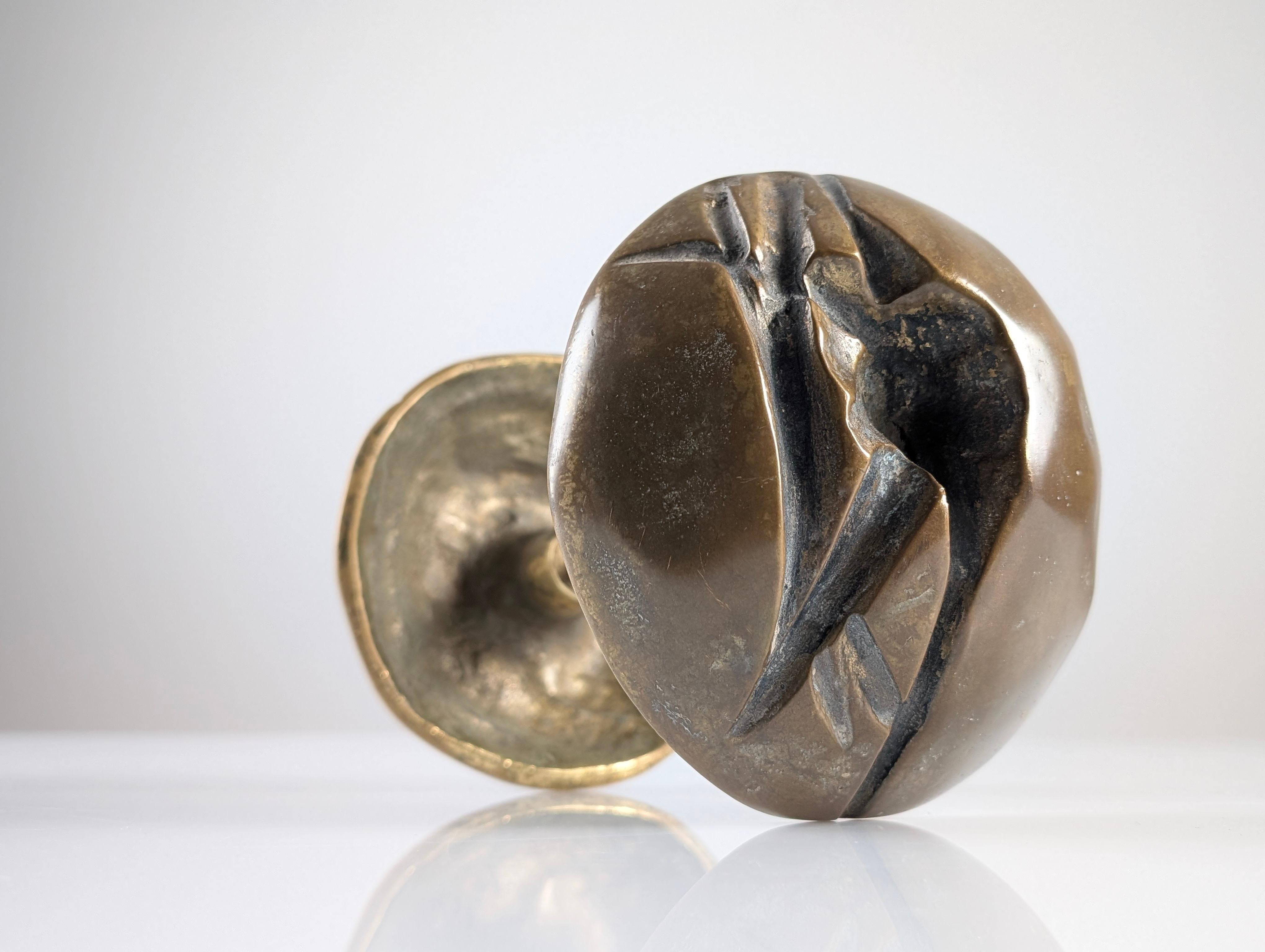 This striking double bronze handle from the 1970s is a rare example of brutalist design. With an organic shape and sculptural texture, its surface features deep reliefs and abstract geometric lines that capture the raw essence and strength of the
