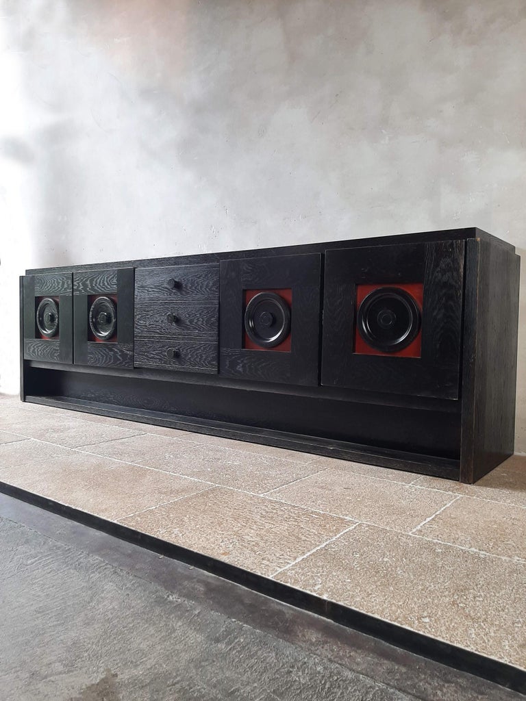 Large, vintage sideboard in Brutalist style. This sideboard has black (ebonized) wood with red contrasting panels. Beautiful timeless design with 4 graphic doors and 3 central drawers.

De Coene, 1970s, Belgium

Measures: width 280 cm, depth 55
