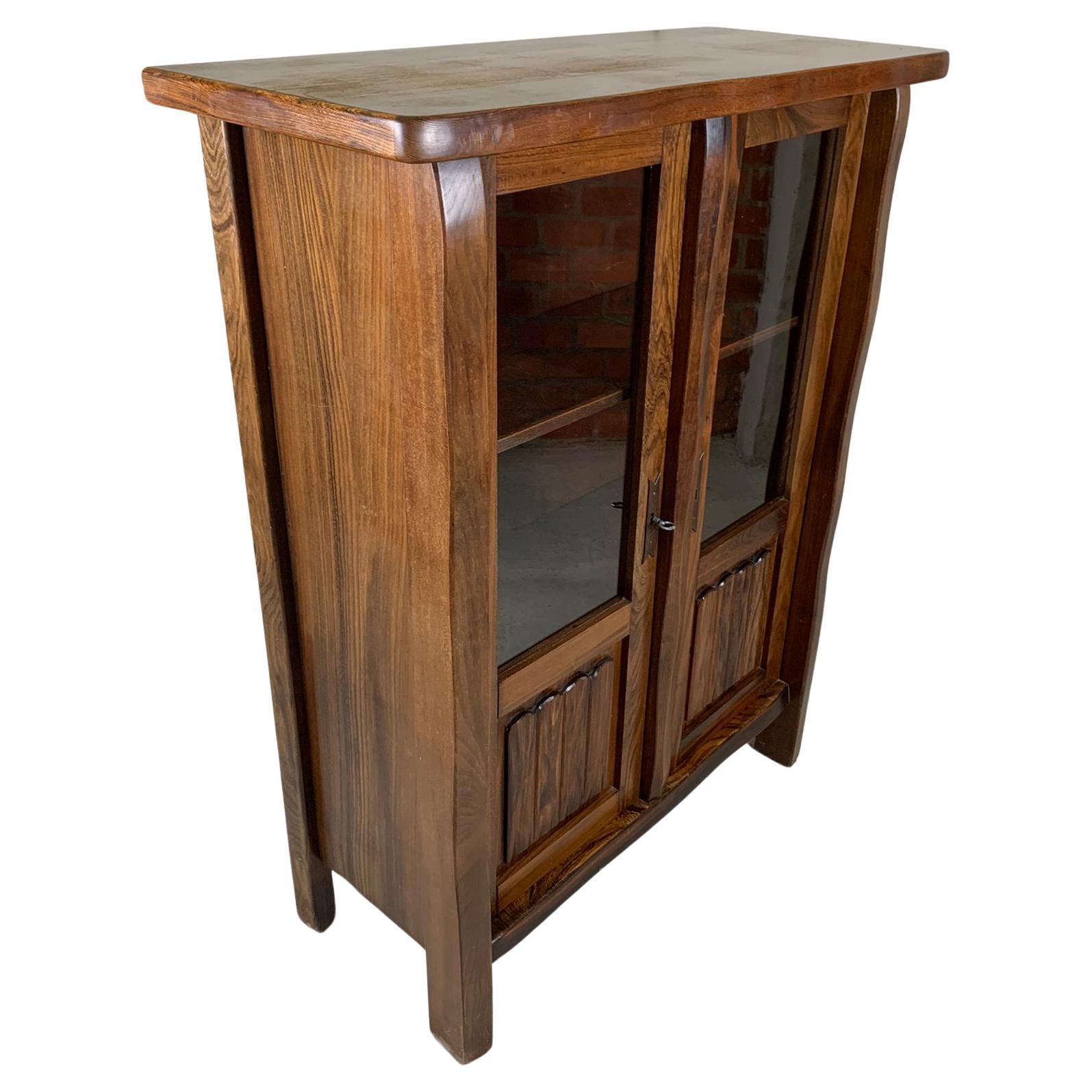 Folk-art Cabinet in solid elm designed by Olavi Hanninen, Finland. The elm shows a rich grain giving this item tons of character. The two door panels are provided with a glass window, therefore it can also be used as show case or dry bar. Both doors