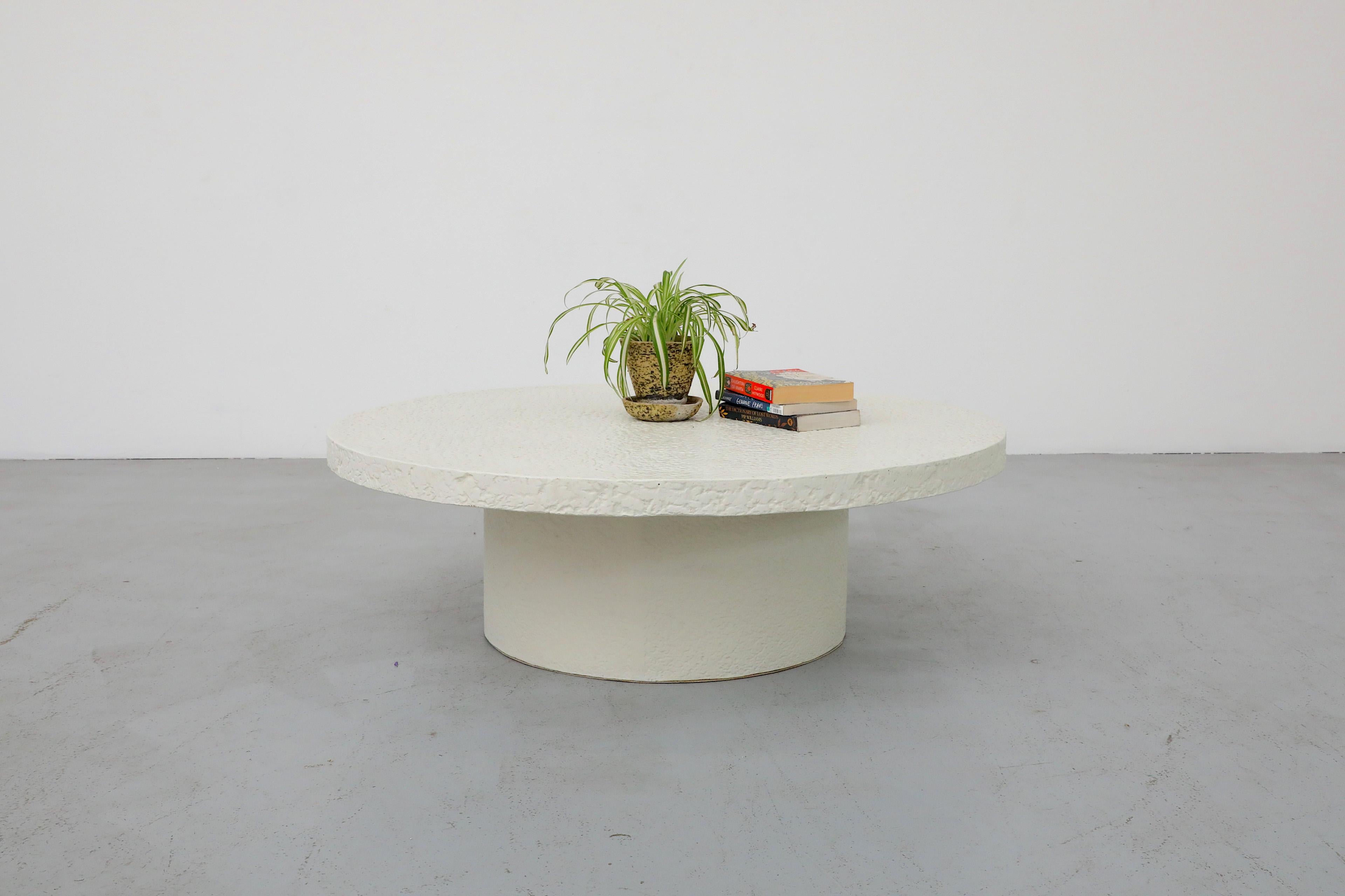 Mid-Century round white faux stone coffee table. Large minimalist coffee table with textured top and base that effortlessly elevates any living space. In original condition with some visible wear consistent with age and use.