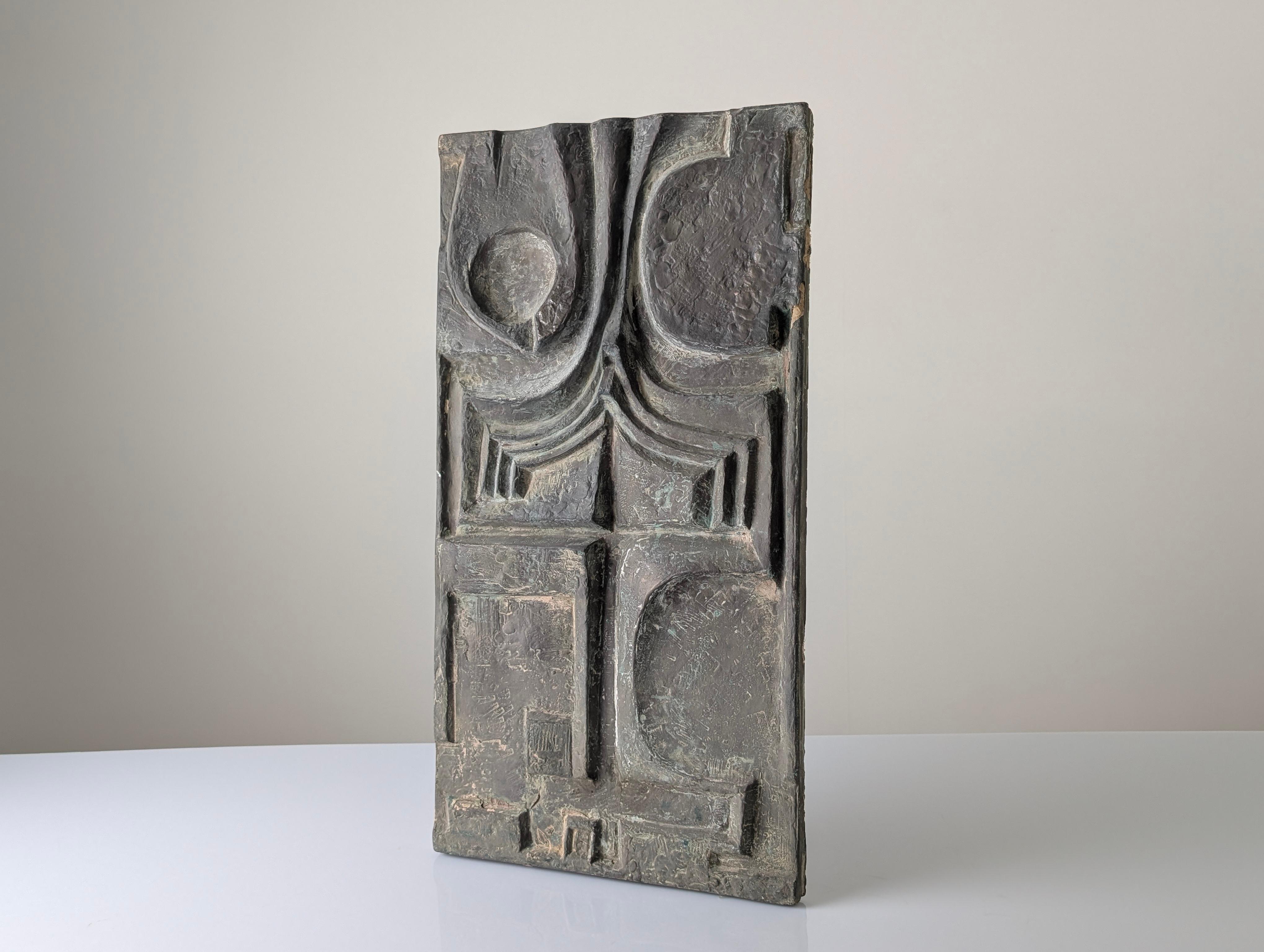 Brutalistische Relieftafel aus Fiberglas aus den 1960er Jahren mit einer abstrakten Oberfläche aus geometrischen Formen und eingeritzten Texturen. Die patinierte Oberfläche in Bronzetönen erinnert an gealtertes Metall und unterstreicht die Tiefe und