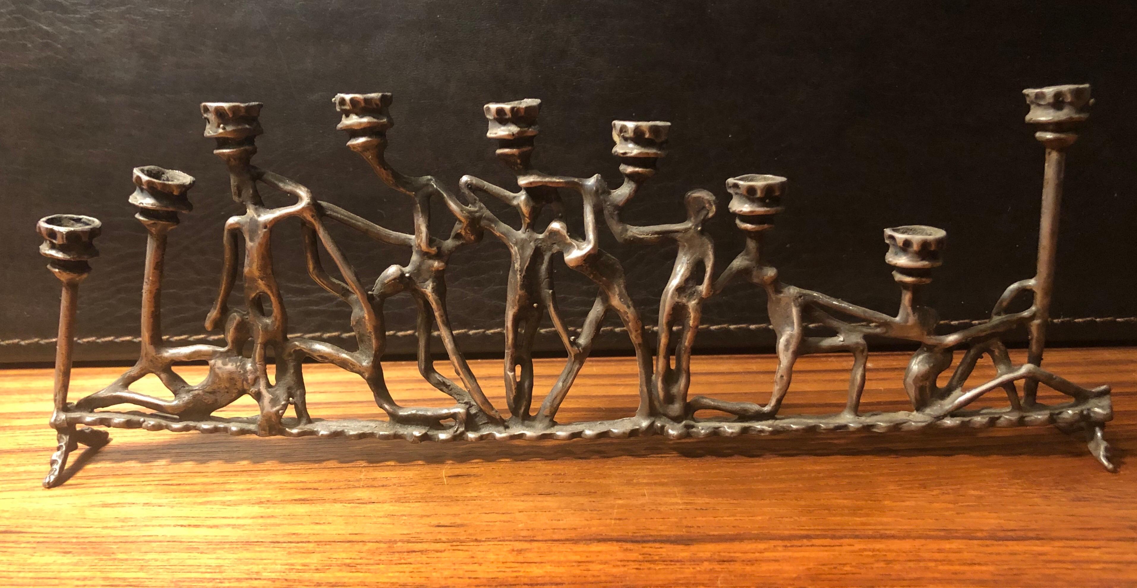 Brutalist figurative iron menorah in the style of Frederick Weinberg, circa 1970s. The piece measures 10.5