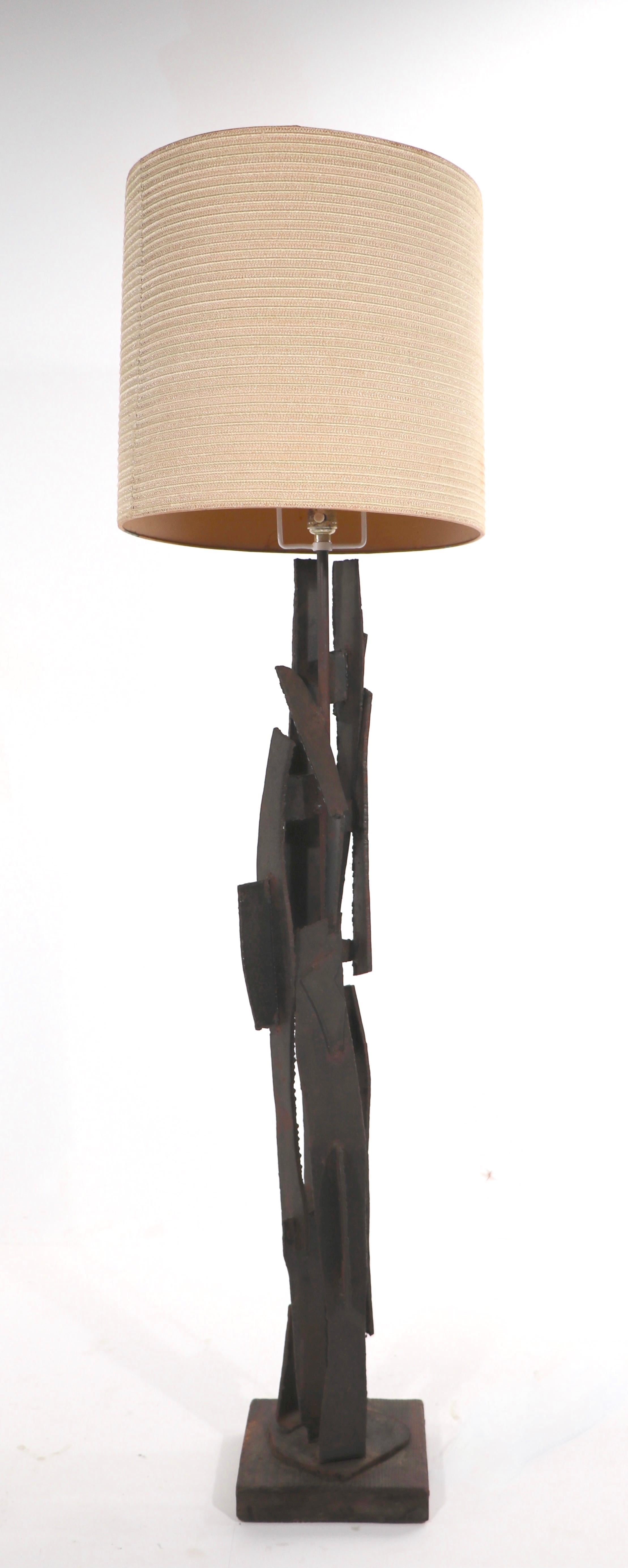 Rare floor lamp version of the iconic Brutalist lamp, designed by Harry Balmer for the Laurel Lamp company. The vertical standard is comprised of torch cut iron, welded together, mounted on a wrought cut wood base, with the classic squared laurel