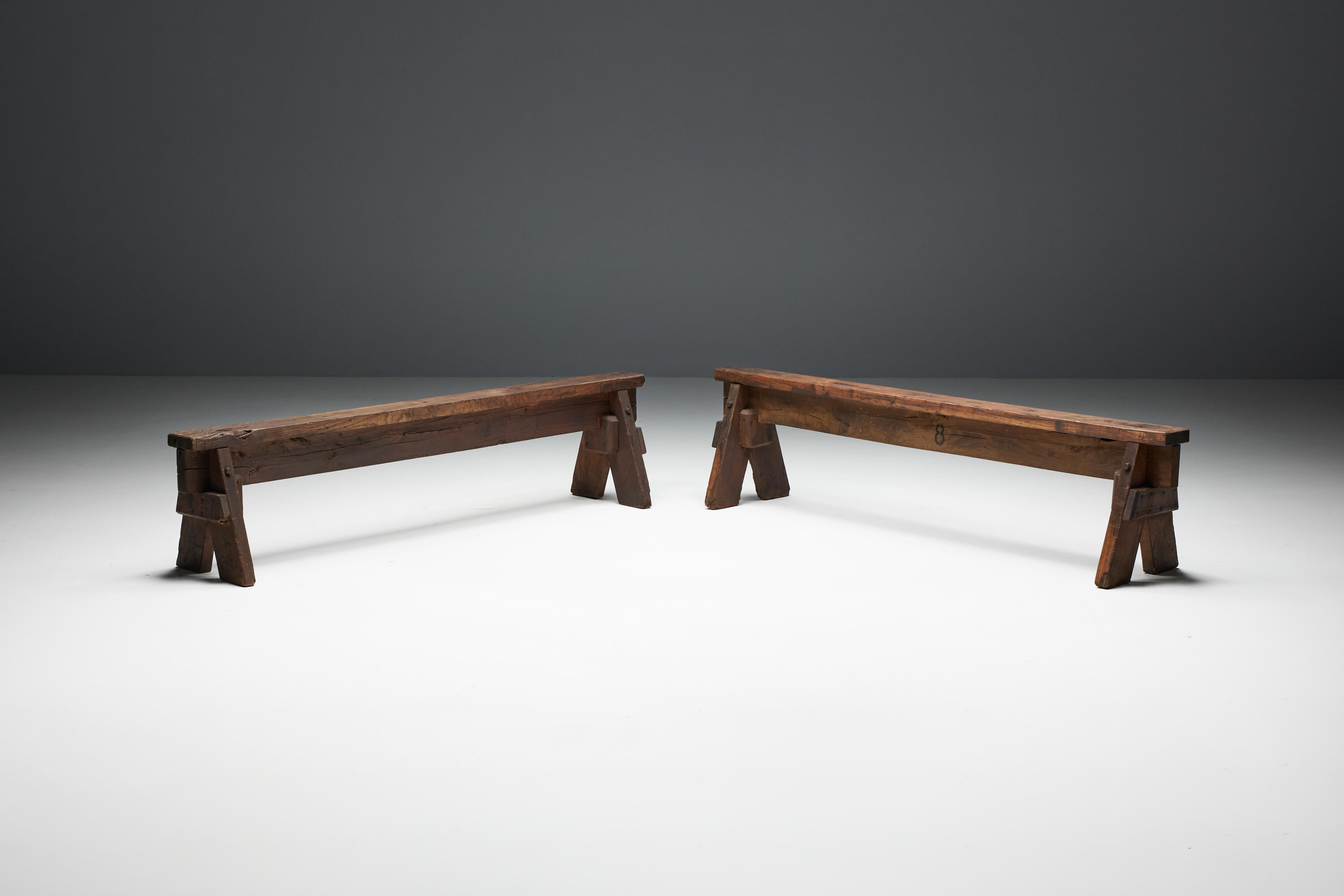 Bancs brutalistes français du XIXe siècle, reflétant l'essence de la beauté wabi-sabi dans leur forme imparfaite. Ces bancs présentent une structure robuste en bois foncé et une patine riche et usée par le temps qui témoigne de leur passé chargé