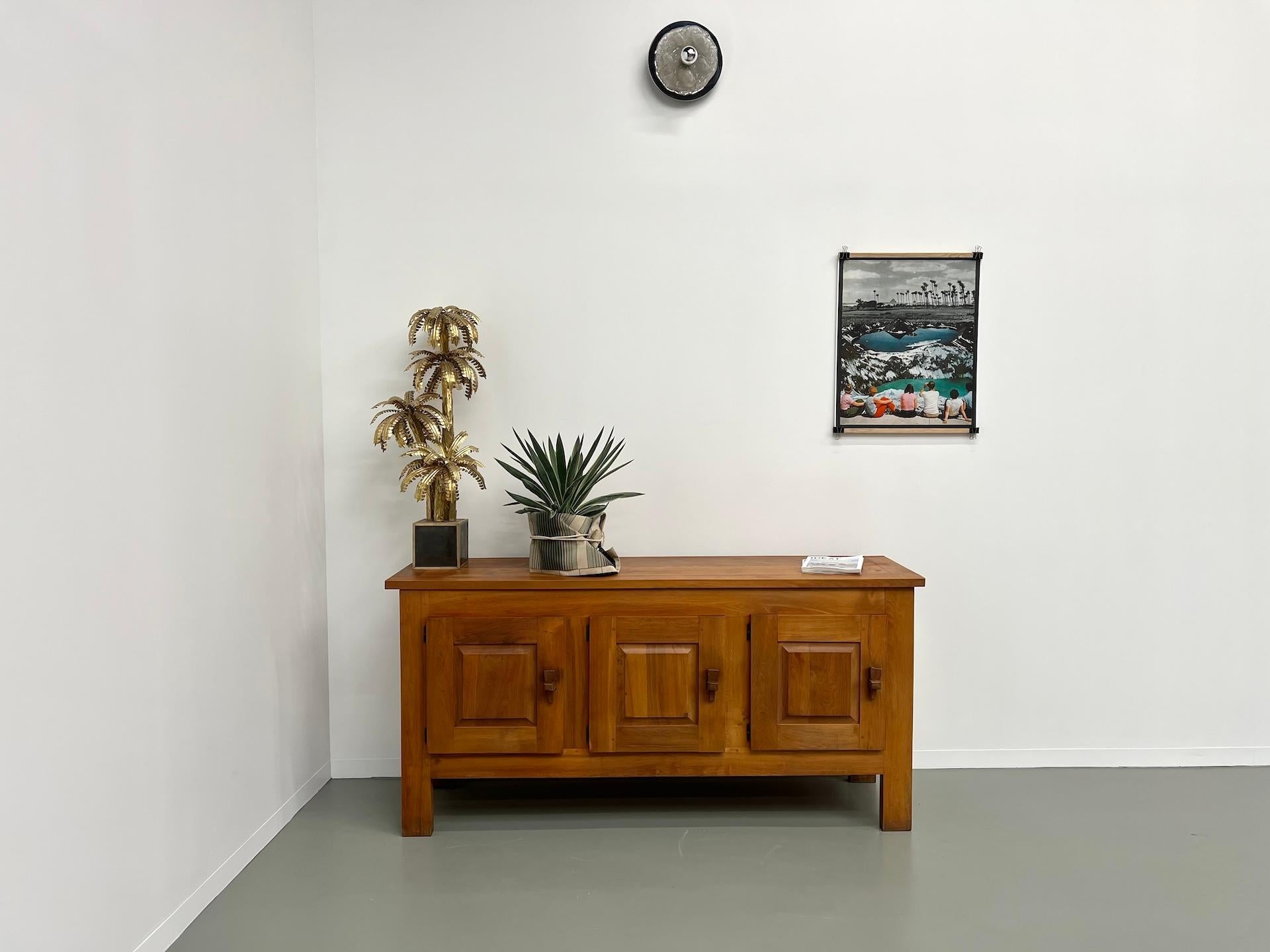 Pretty piece in solid elm with entirely original patina, celebration of craftsmanship and mid-century design, composed of 3 doors closing with shelves. A large central shelf allows you to store numerous accessories, decorative objects or