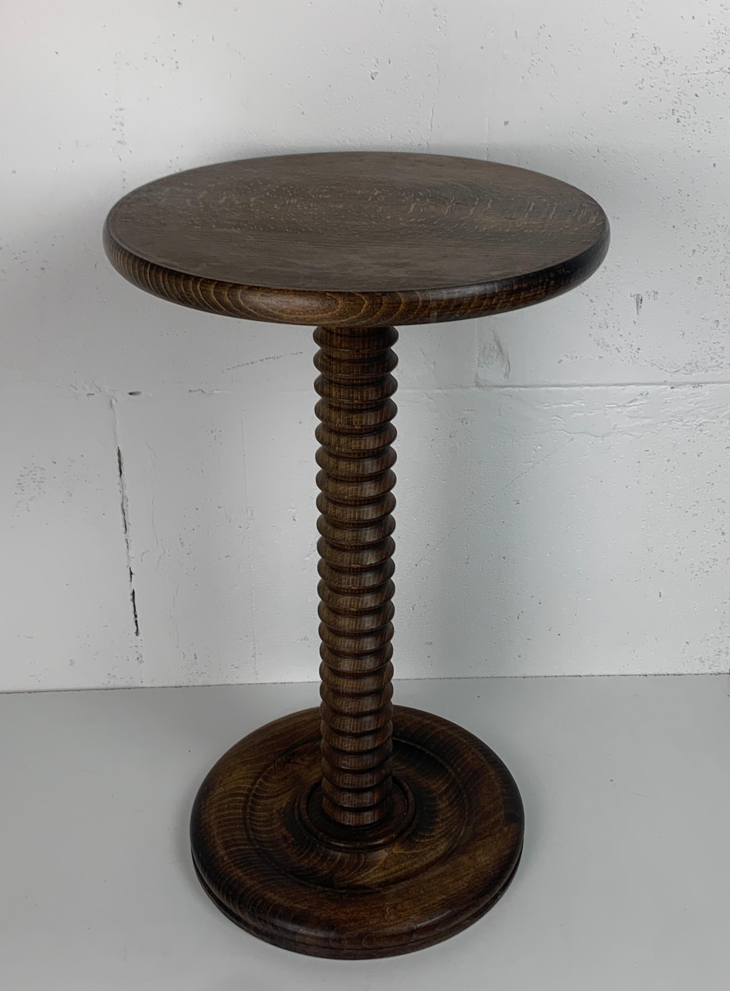 Impresionante mesa auxiliar francesa de pedestal de los años 40-50 construida en roble marrón. Las bases suelen ser de tornillos de lagar antiguos fuera de servicio y muy al estilo de Charles Dudouyt. Esta elegante y delgada mesa puede desmontarse