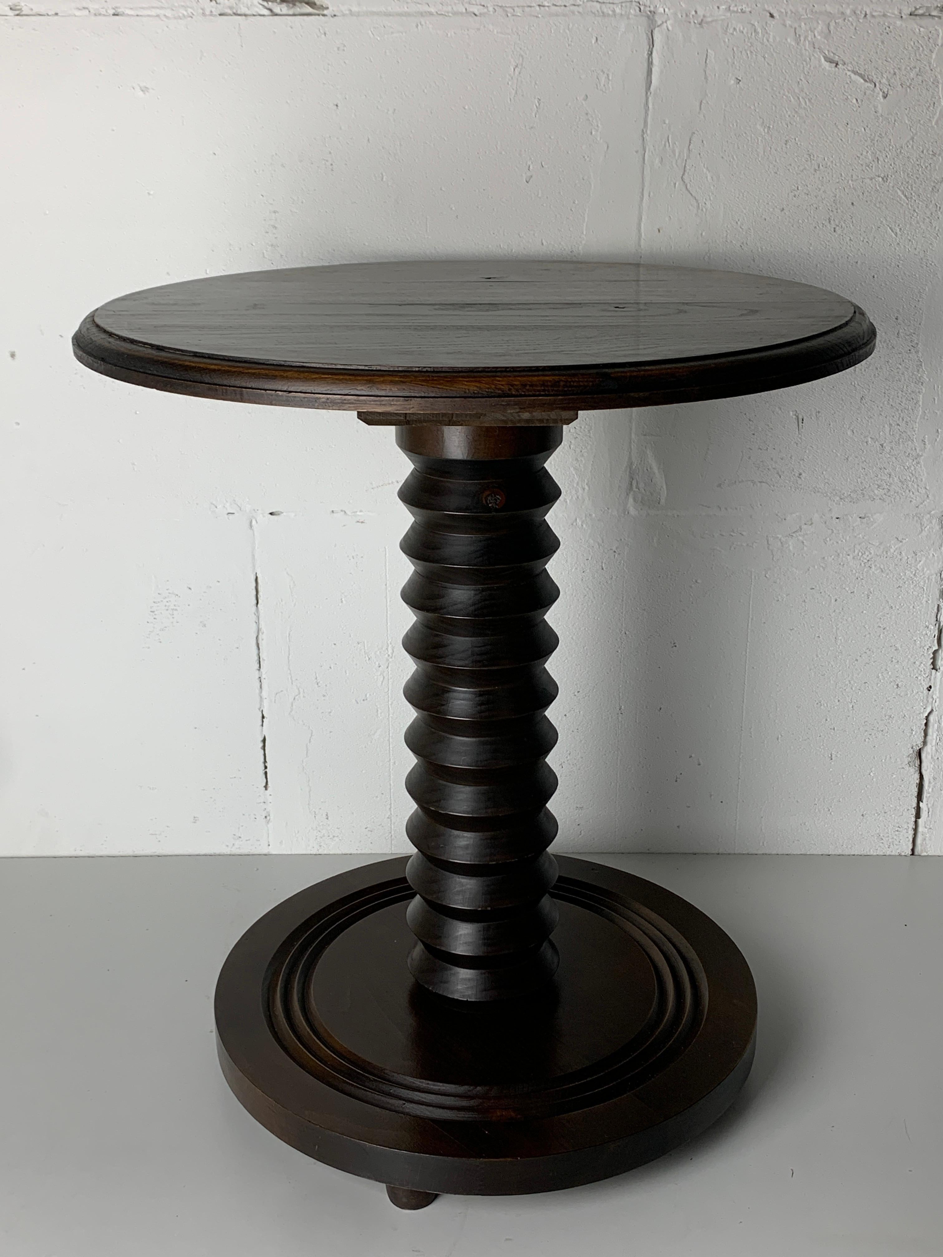 Stunning French side table of pedestal from the 1940s- 1950s constructed in brown oak. The bases are generally made of decommissioned antique wine press screws and very much in the style of Charles Dudouyt. This elegant slim table can be easily