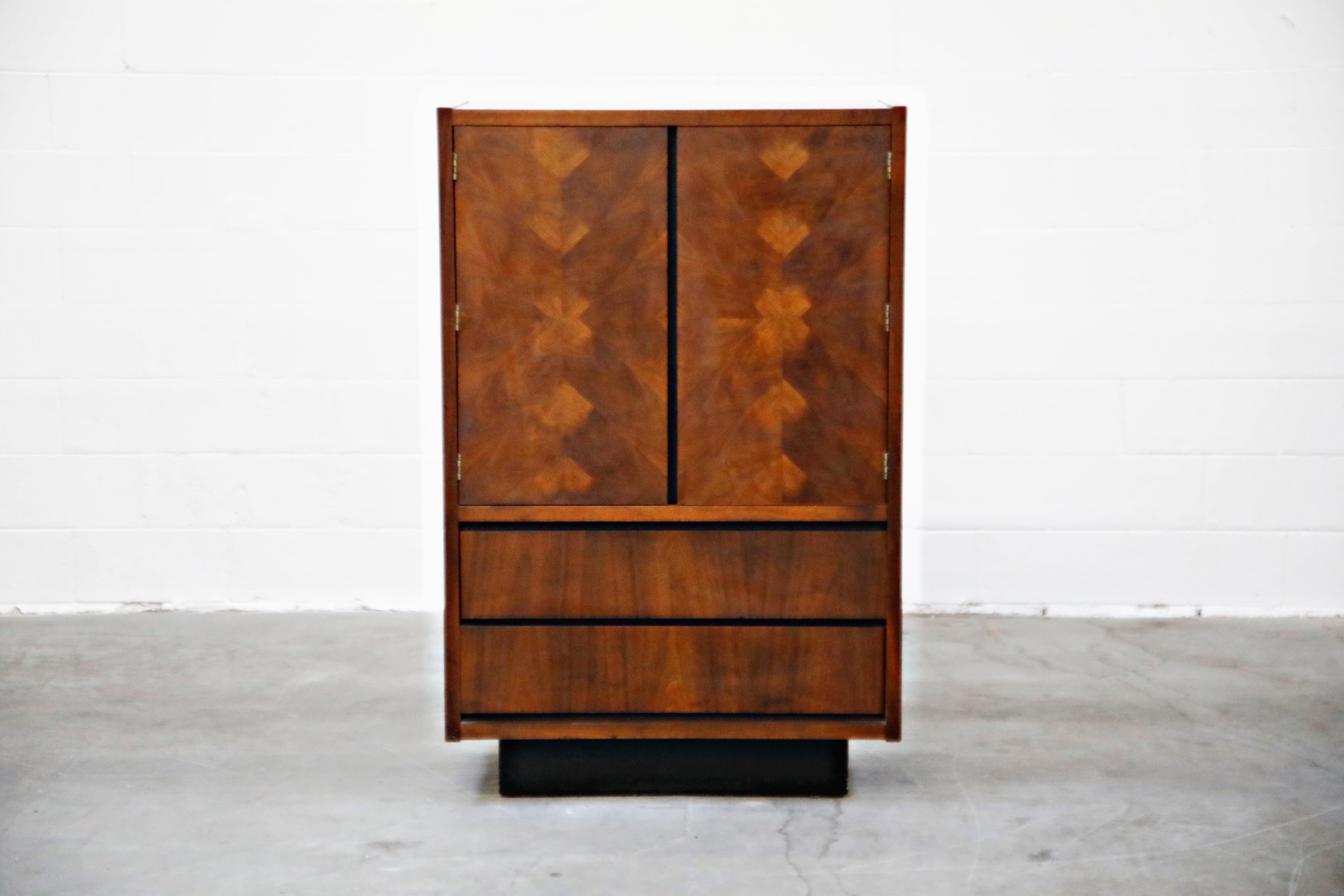A classy and sophisticated 1960s American modern gentleman's highboy dresser by Lane. The burled wood doors and drawers feature a patchwork design with large upper cabinet doors over two drawers standing atop a black plinth base. Inside the upper