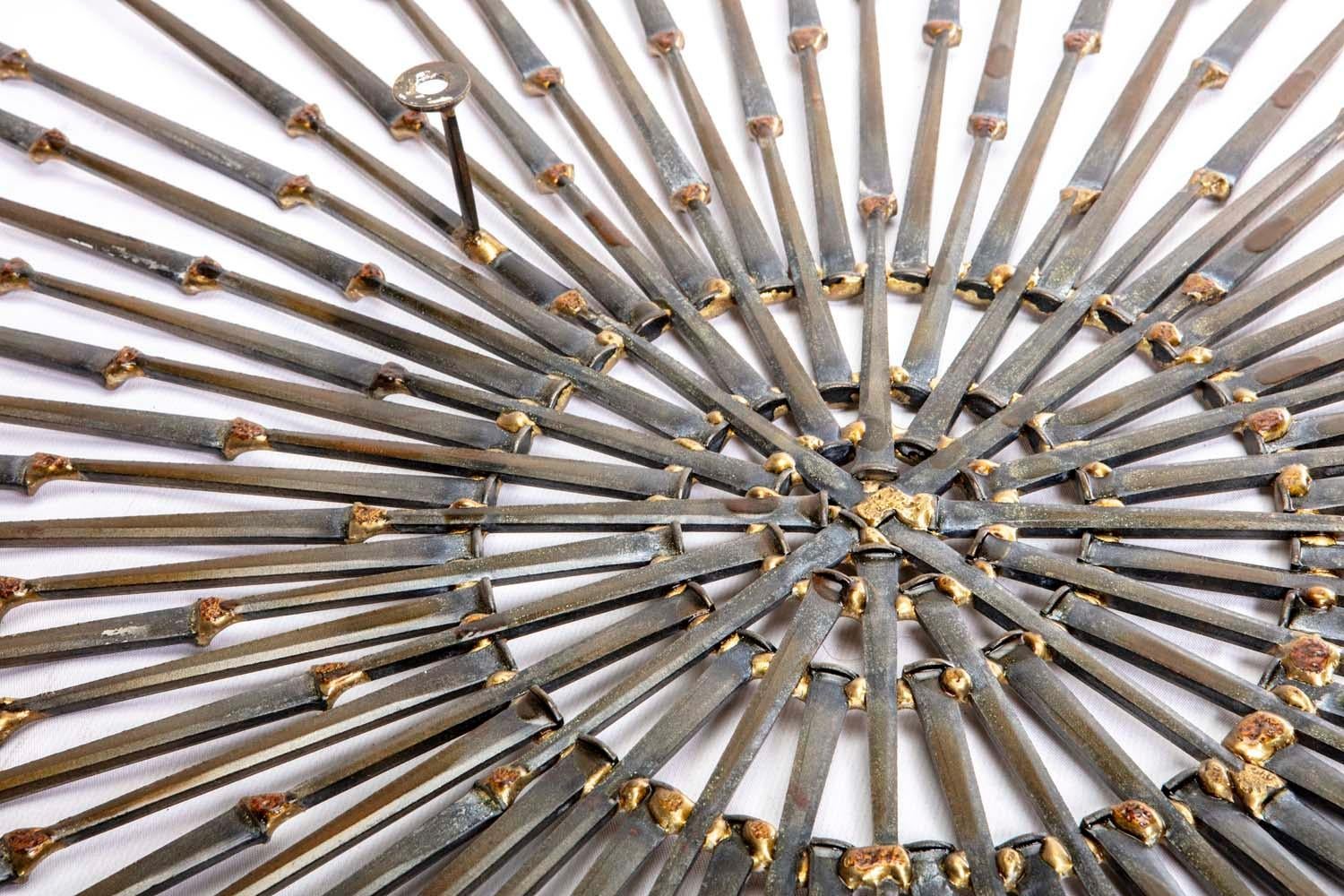 Brutalist sunburst in the style of William Bowie.
William Bowie was a sculpture artist based in New York City from 1954 to 1994. He is best known for his works using welded gold leaf steel nails. As a contemporary of Harry Bertoia, Curtis Jere, and