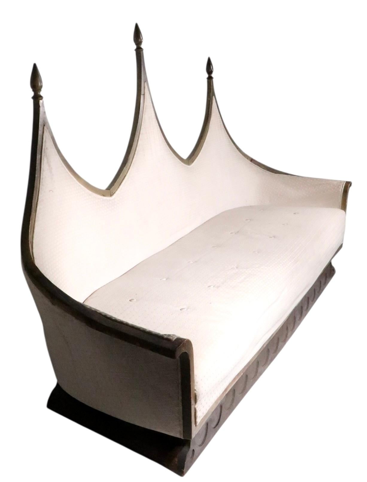    Dramatic Brutalist, Gothic Revival, Boho style sofa, having a cathedral form back with three pointed peaks, boat form seat, and stylized plinth base. 
This example is structurally sound and sturdy, the upholstery is worn and will need to be