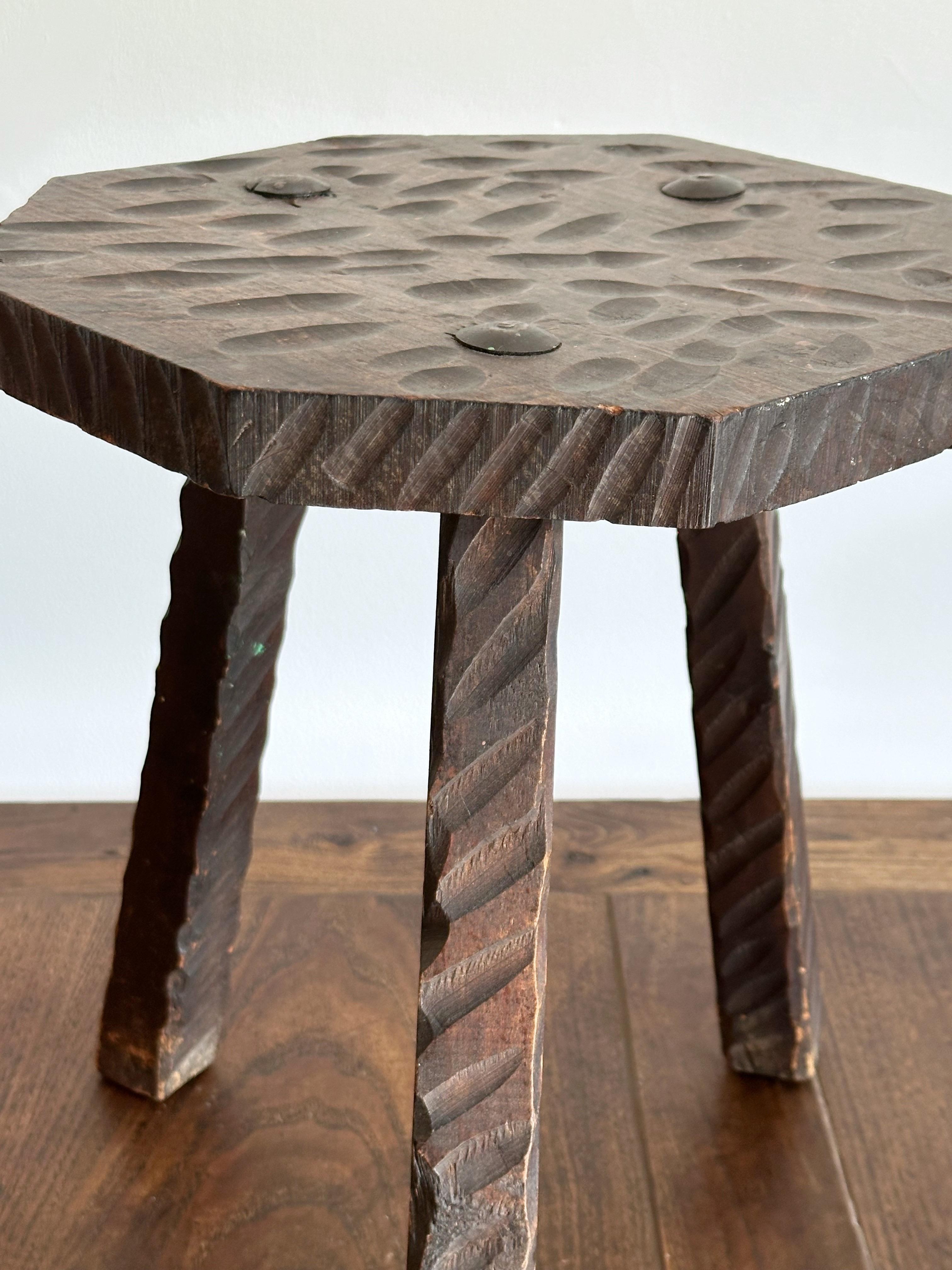 A 1960s French brutalist style stool. Gauge carved wood with metal fasteners.
