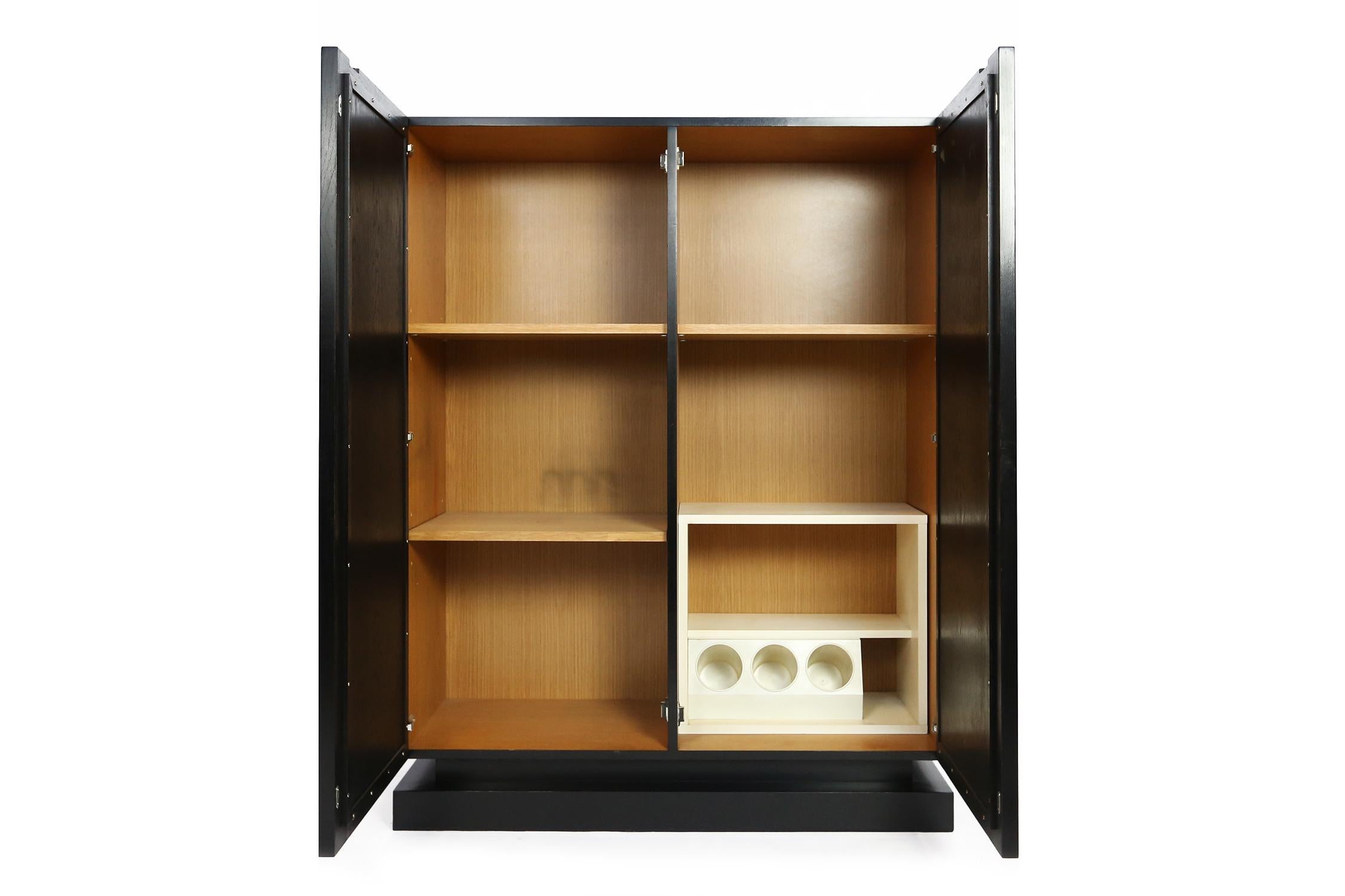 Bar cabinet, in ebonized oak, plastic and wood, Belgium, 1970s.
This cabinet shows excellent woodwork on the two door panels. A combination of squares and circles is combined into a graphical and three-dimensional panel. 
In perfect refinished