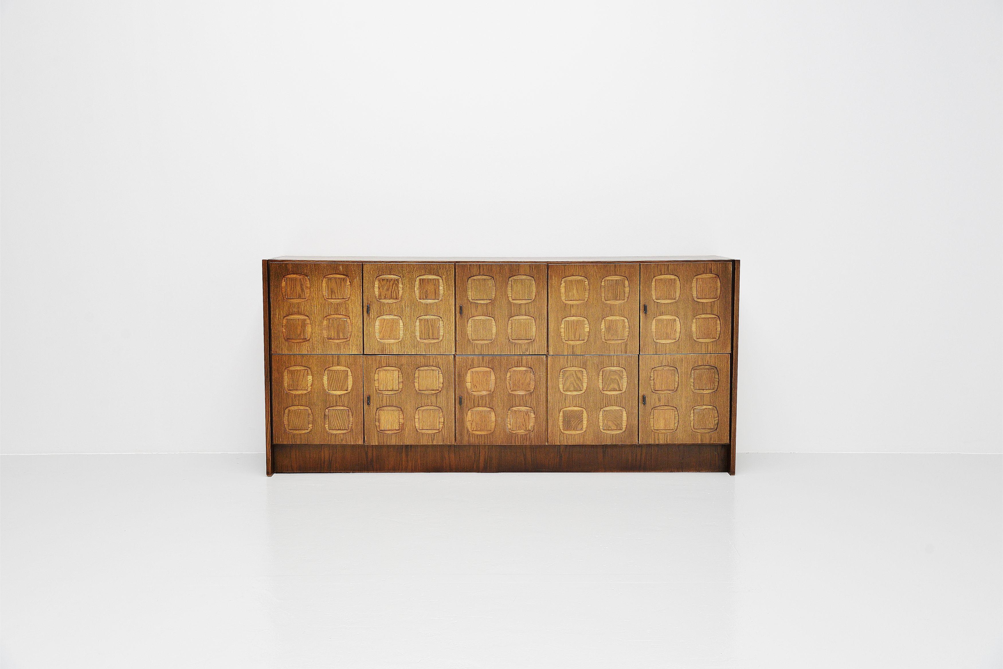 Very nice brutalist high credenza with graphic panelled doors, Belgium 1970. During the 70s there were a lot of small Belgian carpenters and furniture factories who made thee brutalist sideboards with doors finished with graphic panels. De Coene for