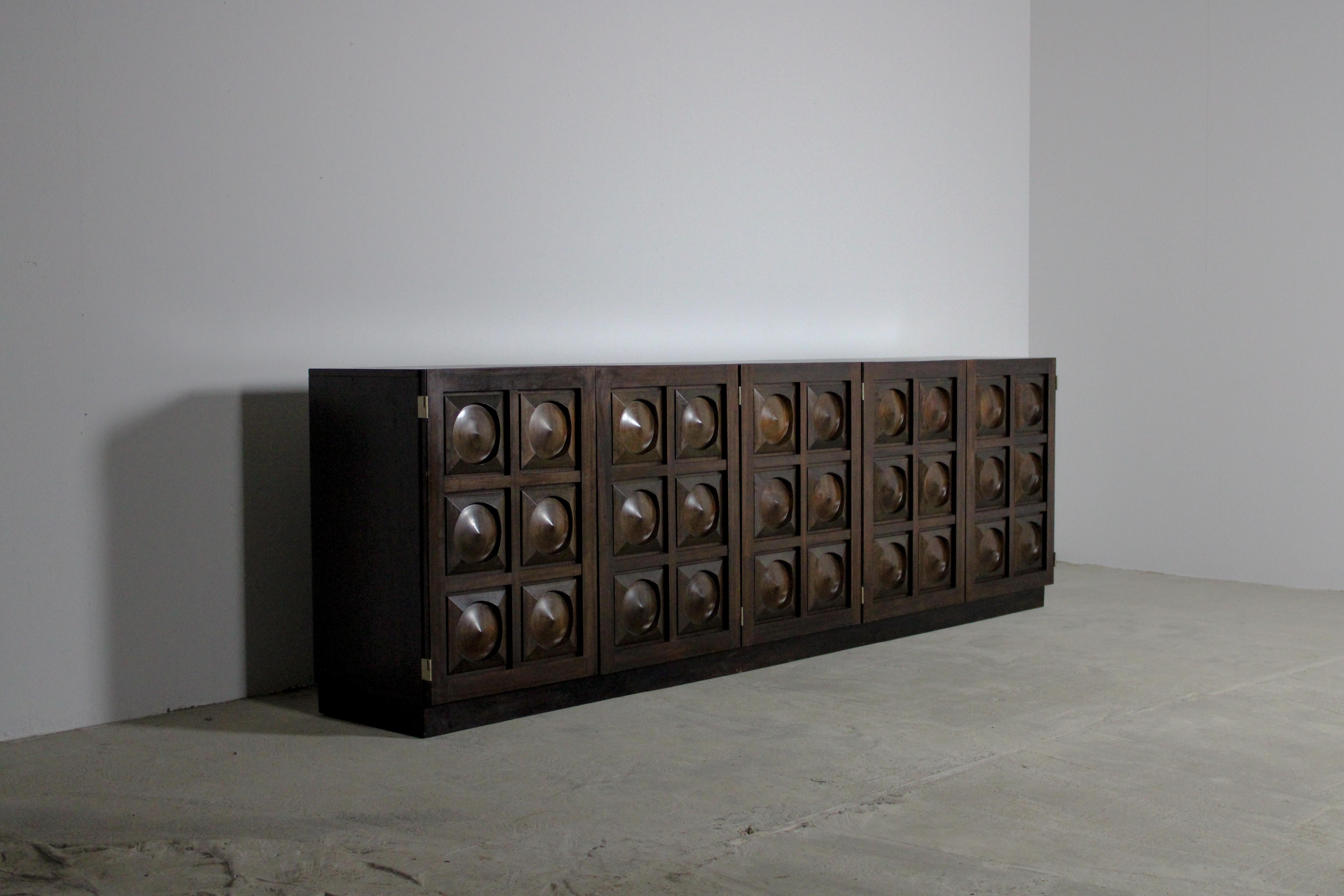 This brutalist sideboard stands as an epitome of raw, unapologetic design—its form an intersection of functionality and bold aesthetics. Crafted from wooden materials, this furniture piece exudes an austere and commanding presence.

Its silhouette