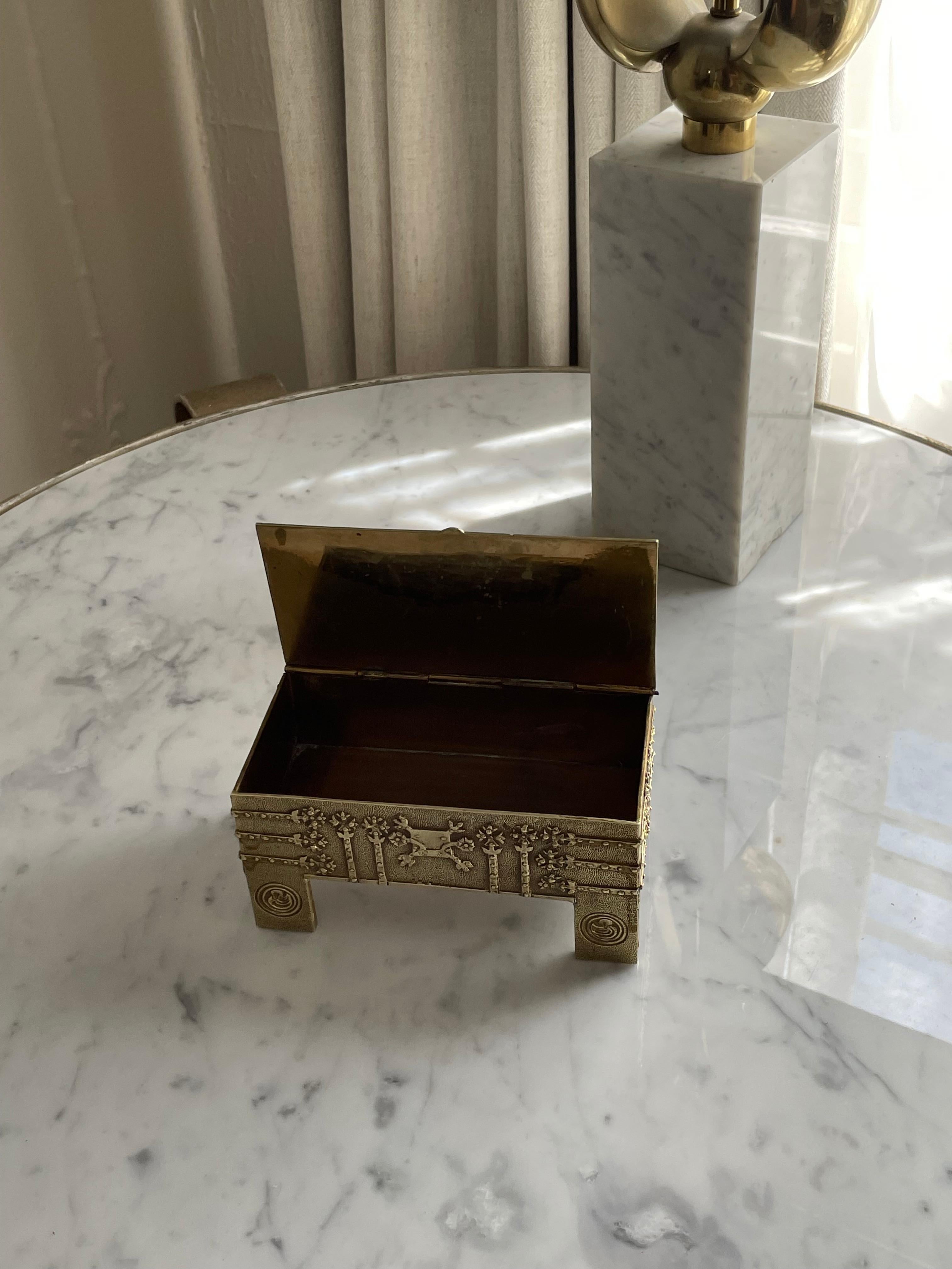 Lidded Brutalist Hand Made box in hammered brass with interesting floral details. Catches light beautifully - a complement to any surface. Can be used as a jewelry box, 420 stash box, or fortune cookie message collection! 

Hinged lid opens and