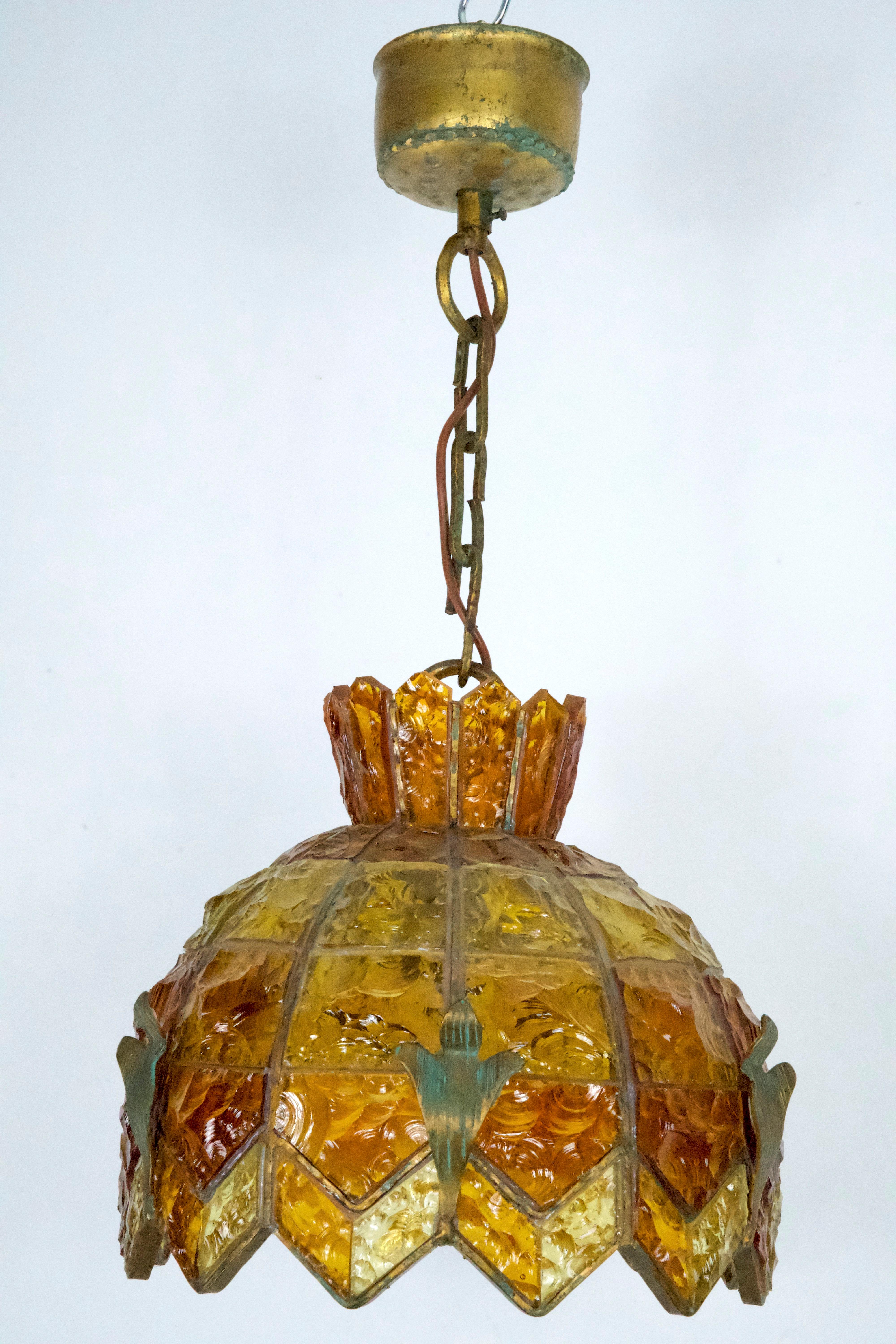 This stunning chandelier, crafted by Longobard in Italy during the 1970s, embodies the distinctive Brutalist style. Made from thick, hammered Murano glass and featuring a gilt and bronzed iron frame, the chandelier showcases a bold interplay of