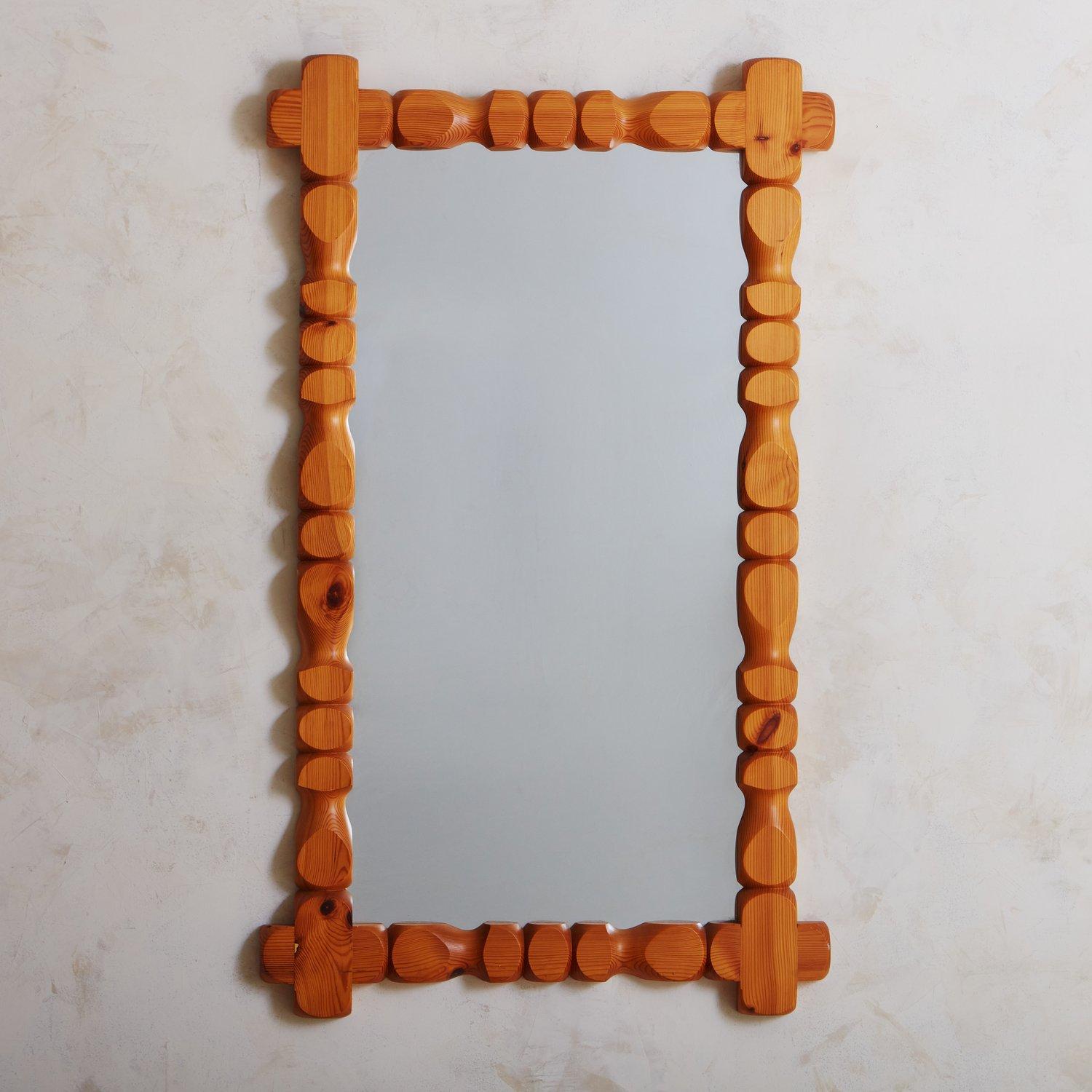 A brutalist 1970s Swedish mirror by Glas Mäster Markaryd featuring an intricate geometric frame hand carved from pine wood. We love the sculptural detailing and rich graining on this beauty. Retains ‘Glas Mäster Markaryd’ manufacturers label en