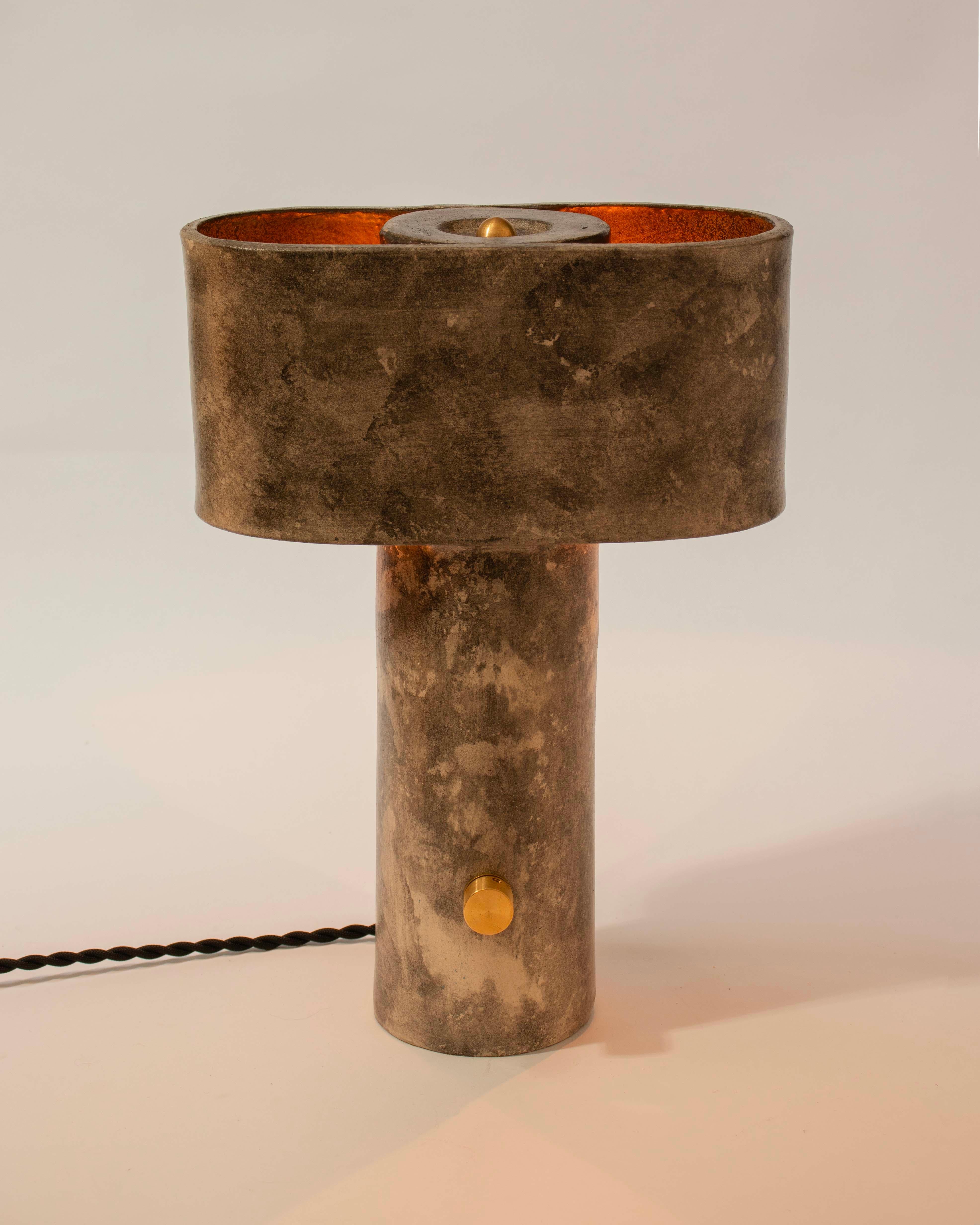 La lampe AT&T est une petite lampe de table d'inspiration brutaliste, parfaite pour un éclairage de chevet ou d'appoint dans les grands espaces de vie, créée par Streicher Goods à Brooklyn, NY. 

La lampe AT&T a une base cylindrique fine qui