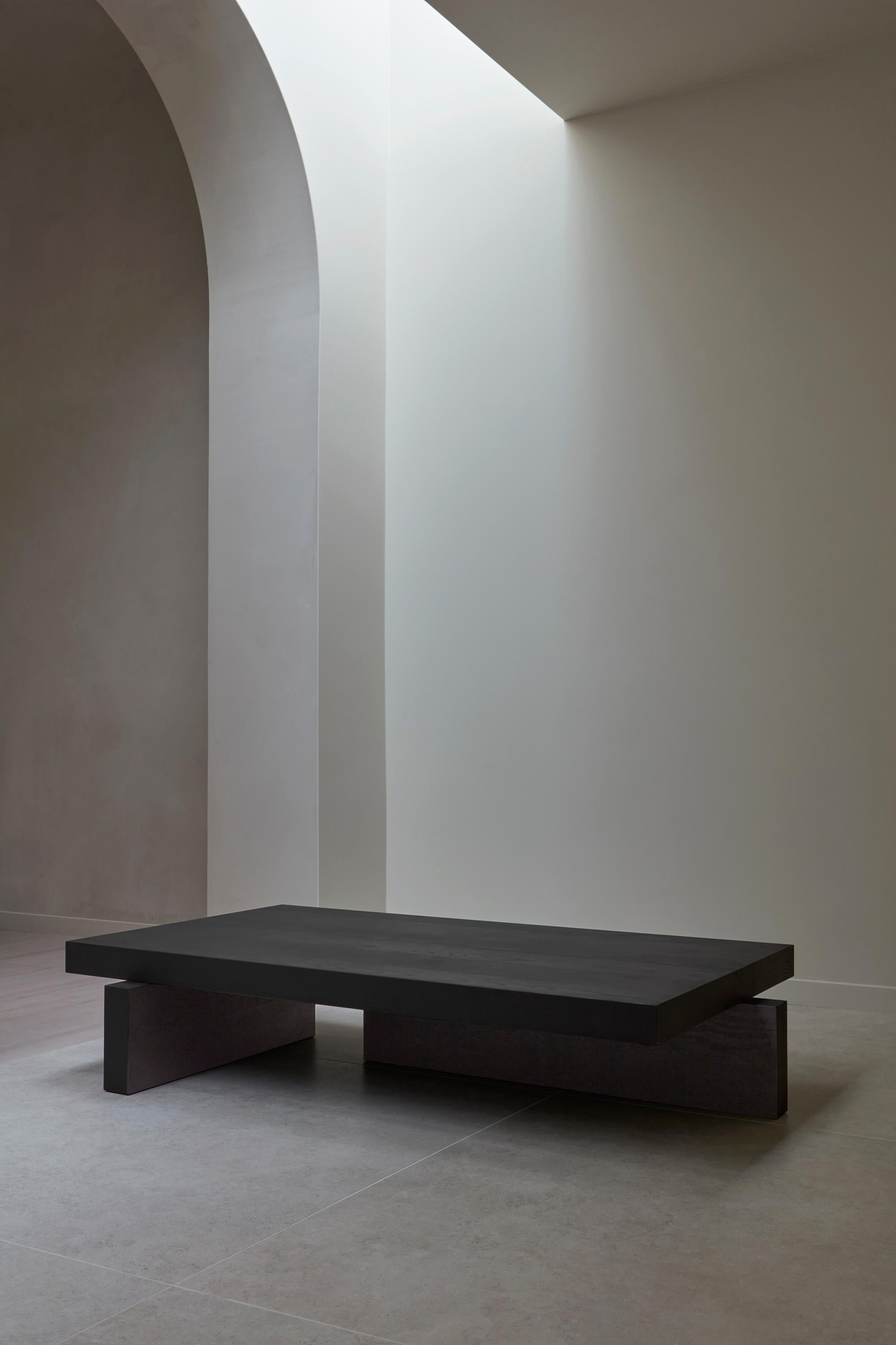 Japanische Ästhetik kombiniert mit brutalistischen Volumina. Der Hari Table ist ein Couchtisch aus Massivholz mit asymmetrischen Beinen und großzügigen Proportionen, inspiriert von traditionellen japanischen Holzkonstruktionen. Entworfen von Aad Bos