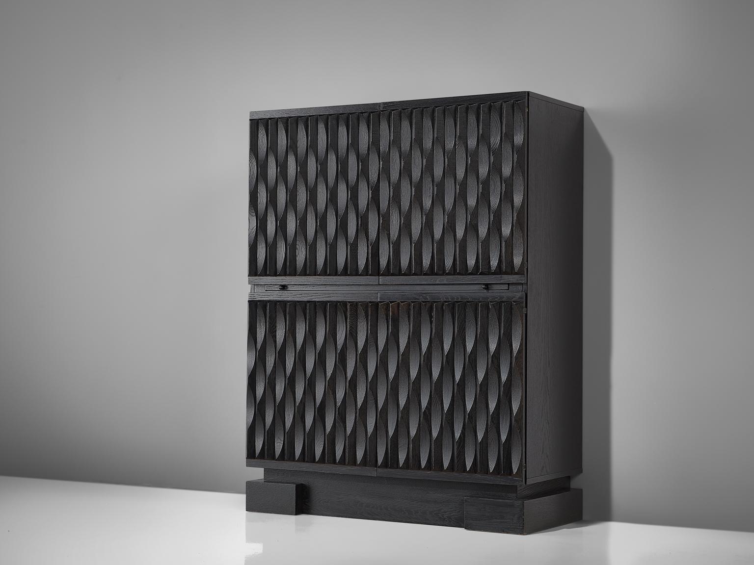 Brutalist black highboard, oak, Belgium, 1970s. 

Sturdy high-board in oak with a black finish. Four door panels, each with a exceptional and very graphic, three-dimensional pattern. The continuous pattern gives this bar-cabinet a very strong
