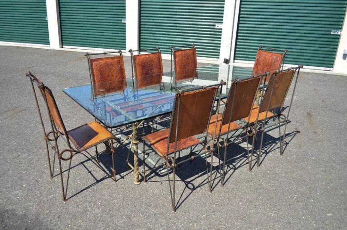 Ensemble de salle à manger vintage en fer et verre de style Brutalist Ilana Goor. La liste comprend une grande table de salle à manger en verre et en fer et 8 chaises en fer avec sièges et dossiers en cuir vieilli. La table est dotée d'une lourde