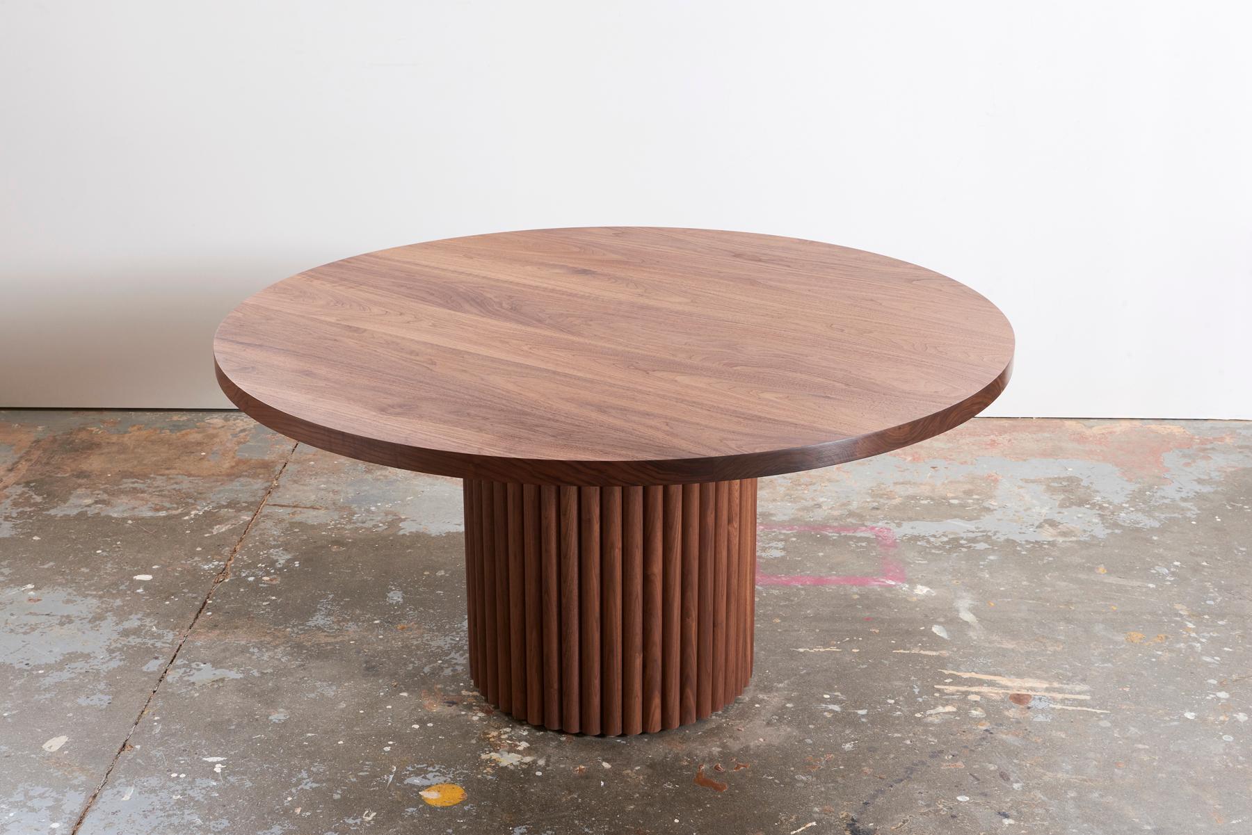 Intrépide, la table à manger de Kate Duncan est une pièce qui rend hommage à la fois à l'esthétique contemporaine et à l'architecture brutaliste. Une grande colonne de cannelures taillées et un plateau en bois massif massif créent une table