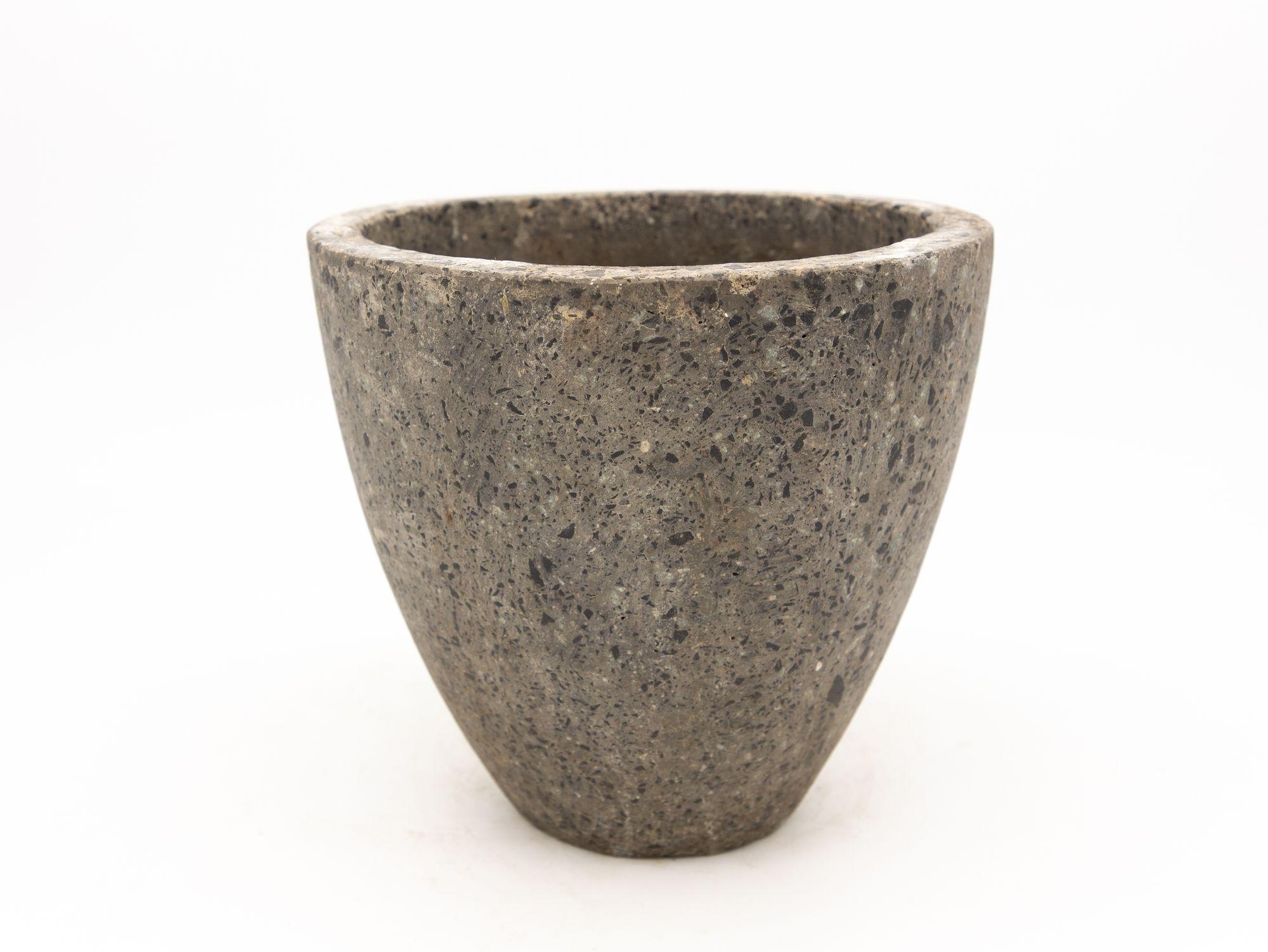 Introducing a captivating small round planter that embraces the raw and powerful aesthetics of brutalism. This planter, crafted from a blend of mixed stone and concrete, exudes a distinct character and visual allure. Its compact Size allows it to be